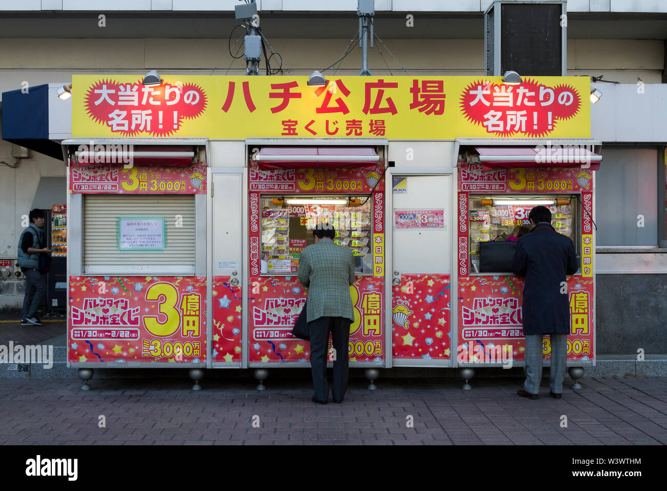 Männer kaufen Lottotickets an einem Kiosk, an dem die japanische Lotterie auf dem Hachiko-Platz in Shibuya, Tokio, Japan verkauft wird. Stockfoto