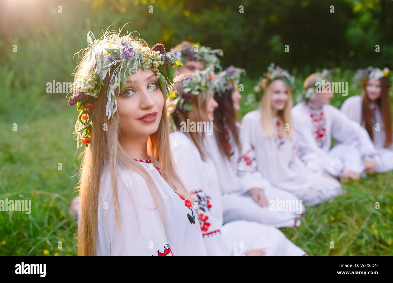 Hochsommer. Sind eine Gruppe von jungen Menschen der Slawischen aussehen Sitzen am Lagerfeuer. Stockfoto