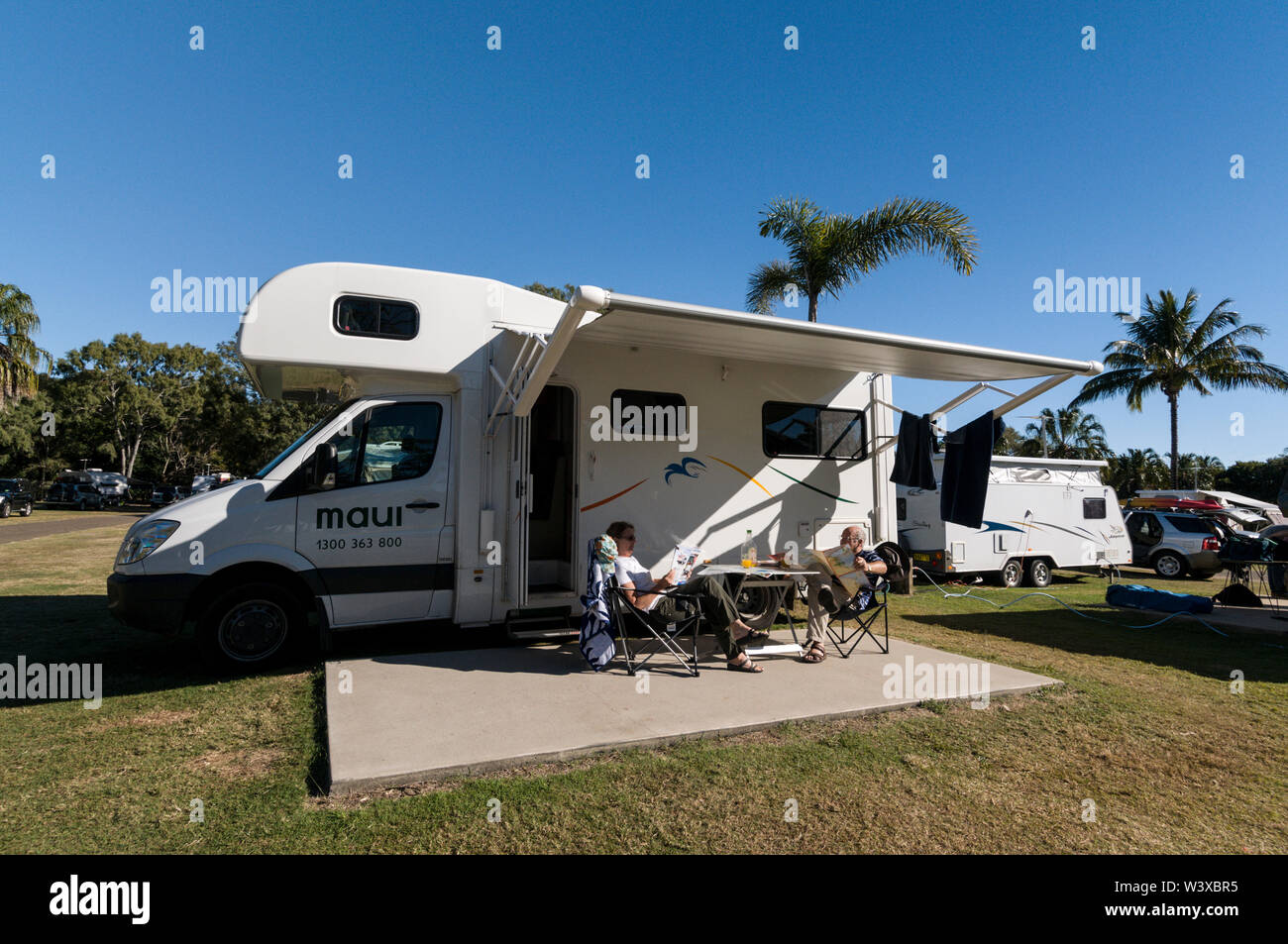 Ein Paar auf einem Wohnmobil Urlaub, frühstücken während der warmen Australischen Winter Sonnenschein an Agnes Water Beach Caravan- und Campingplatz in Queensland, Stockfoto