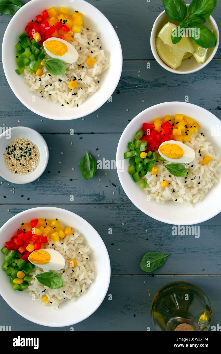 Reissalat mit Gemüse, Sesam und Eier auf Holz- Hintergrund. Ansicht von oben mit der Kopie. Gesundes Essen. Stockfoto