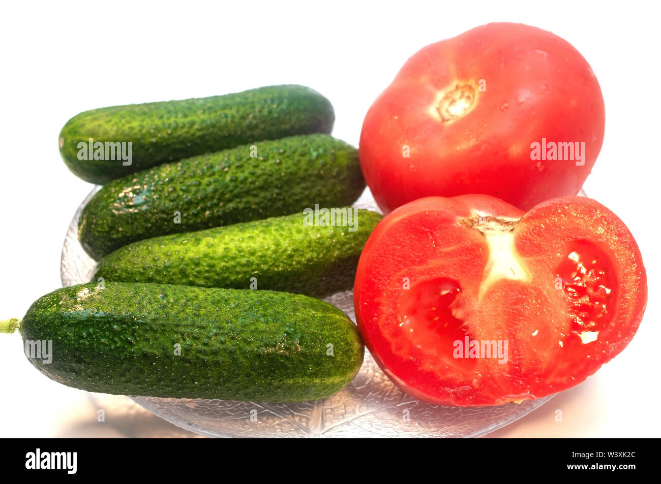 Gurken und Tomaten in einer Platte auf weißem Hintergrund Stockfoto