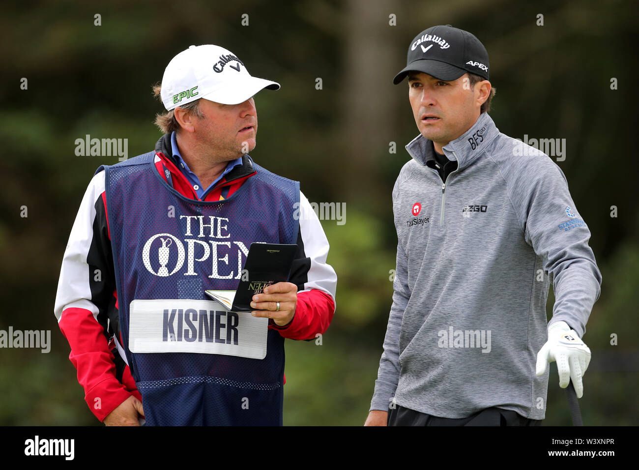 Die USA Kevin Kisner (rechts) vor seinem T-Stück aus dem 5. Tag eines der Open Championship 2019 im Royal Portrush Golf Club. Stockfoto