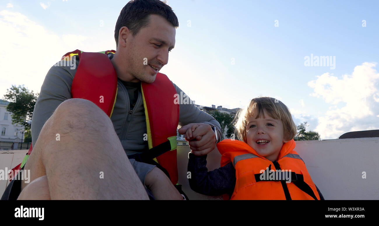 Vater und Sohn auf dem Boot in Schwimmwesten Stockfoto