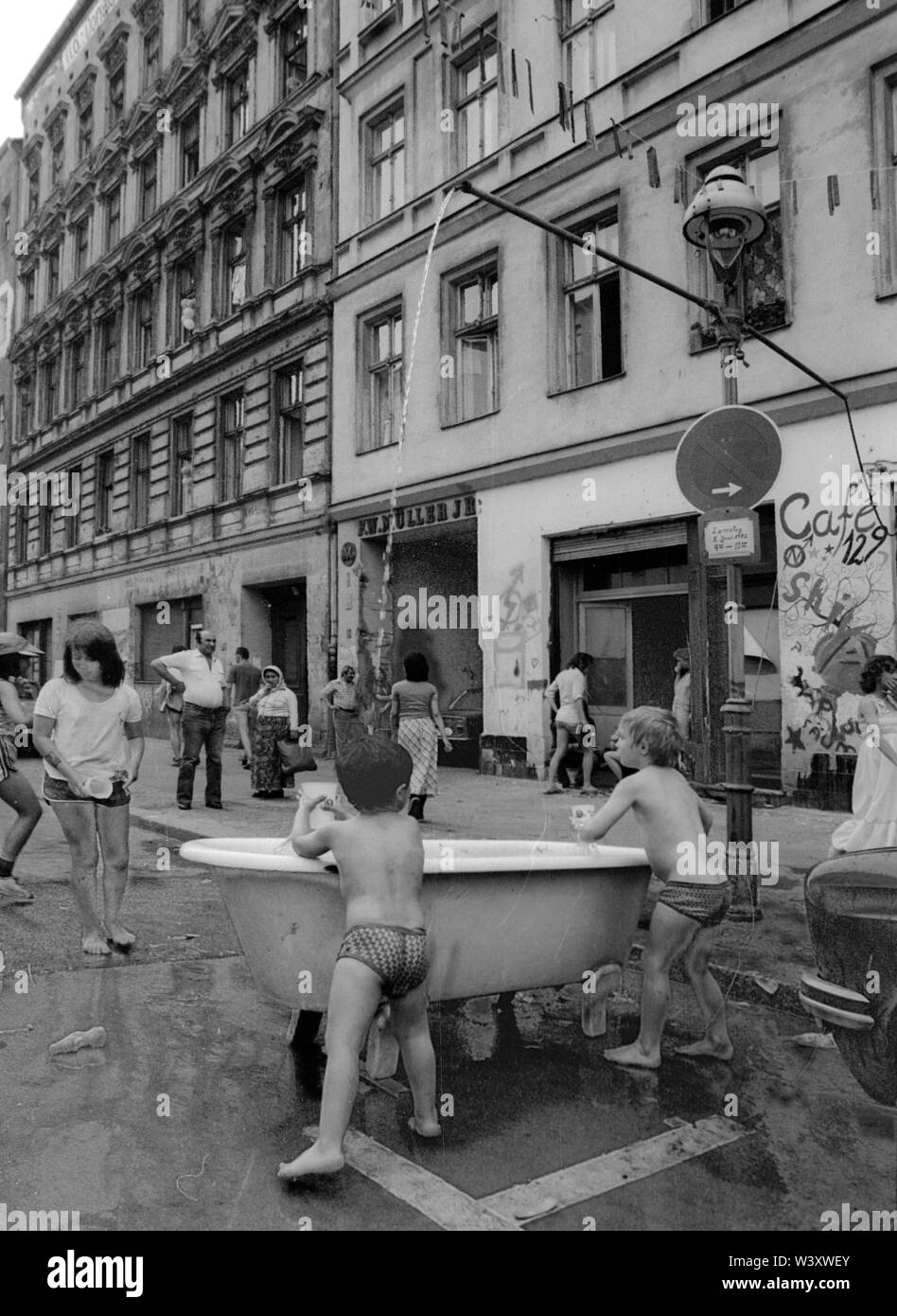 Eingereicht - 01. Januar 1982, Berlin: Berliner Bezirke/Kreuzberg/5.6.1982 Cuvrystrasse. Bewohner haben eine Kreuzberg Badehaus: eine alte Badewanne, einen gartenschlauch auf die Laterne gebaut. Ein großer Spaß für die Kinder. //Gehäuse/Sommer/Armut/Foto: Paul Glaser/dpa-Zentralbild/ZB Stockfoto