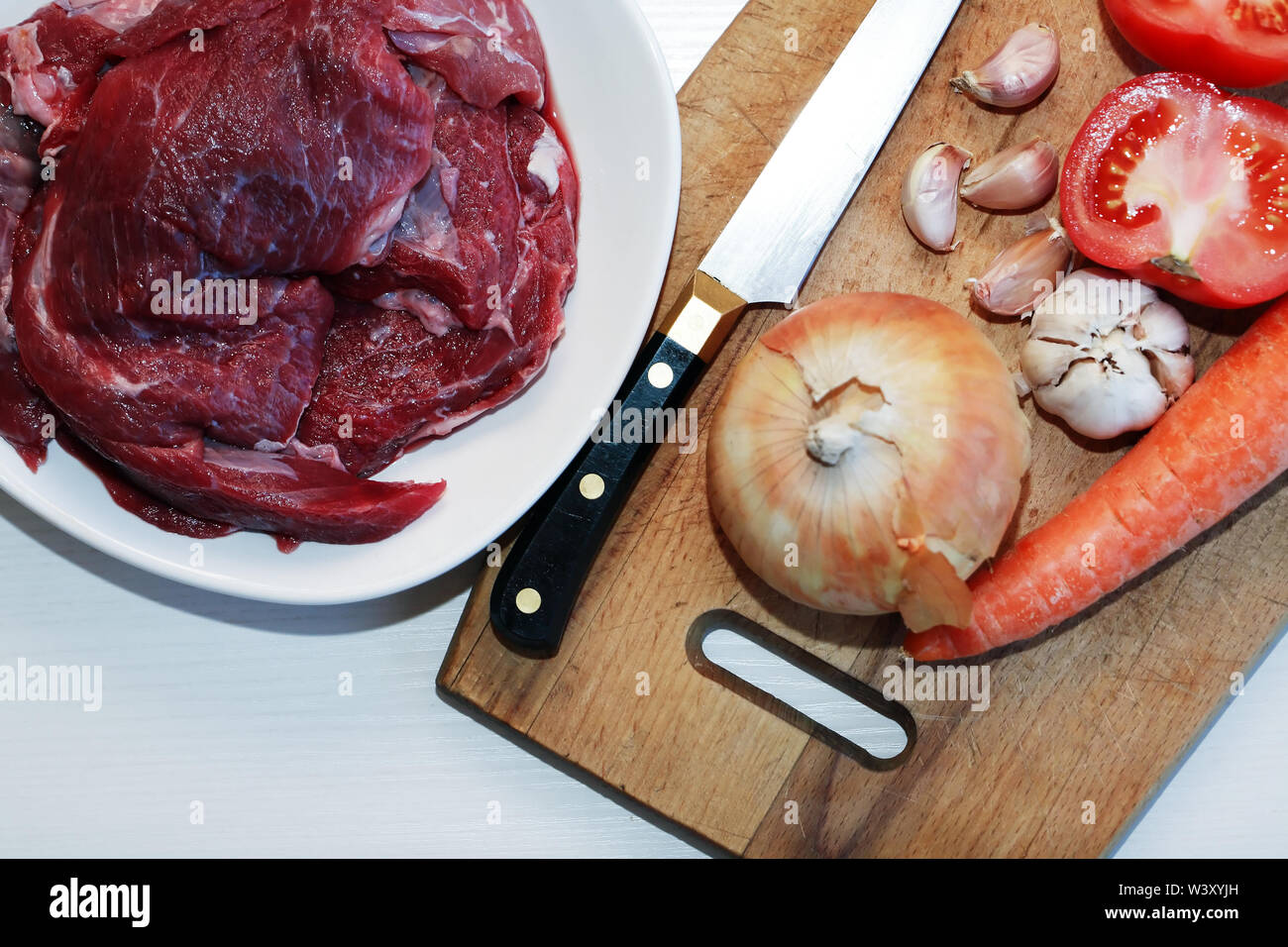 Teil von rohem Rindfleisch für das Kochen in der Nähe von Gemüse Stockfoto