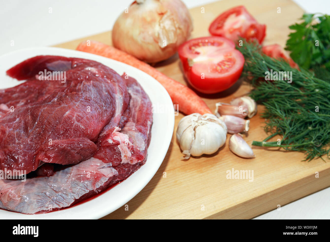 Teil von rohem Rindfleisch für das Kochen in der Nähe von Gemüse Stockfoto
