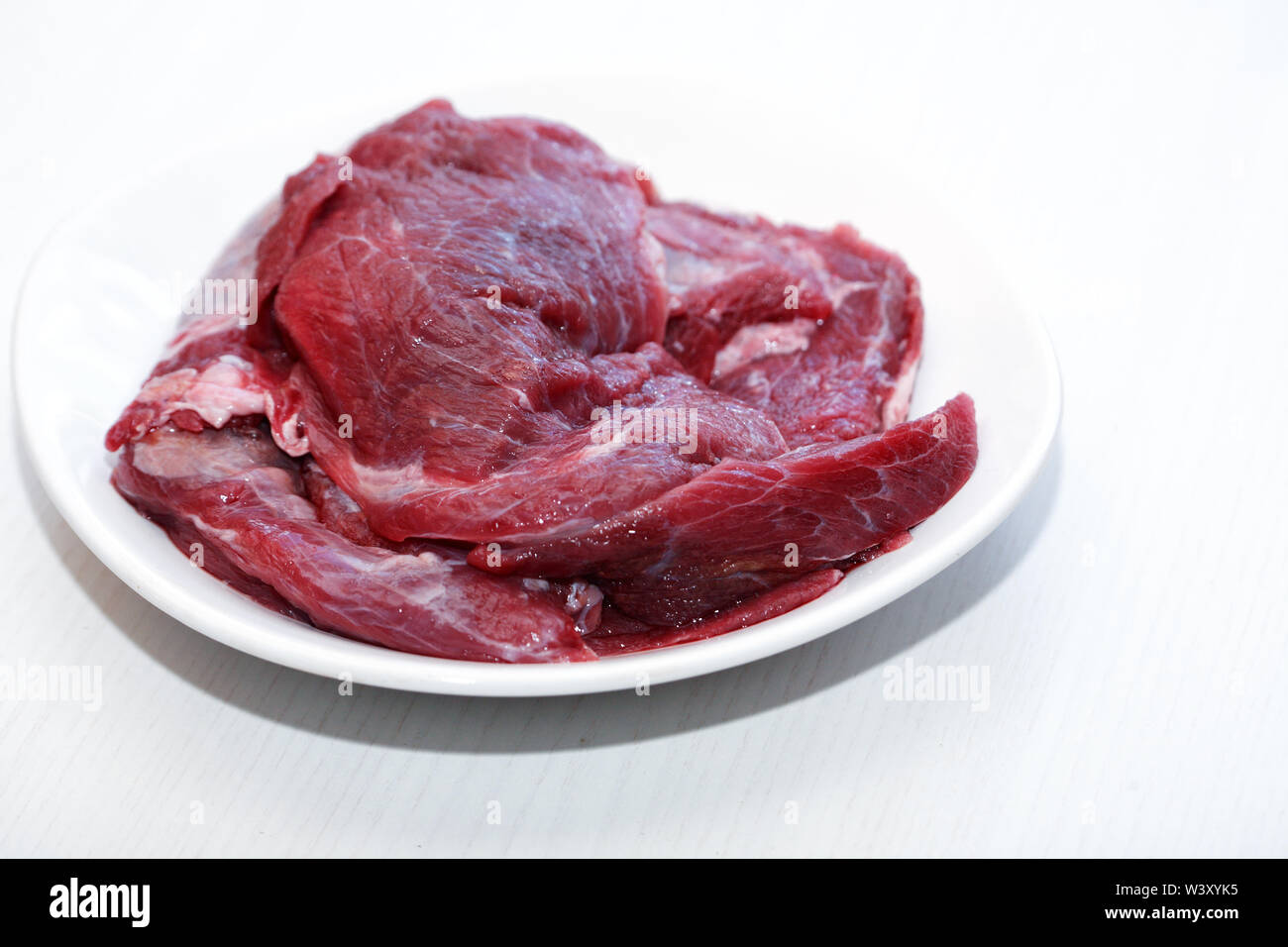Teil von rohem Rindfleisch für das Kochen auf weiße Platte Stockfoto