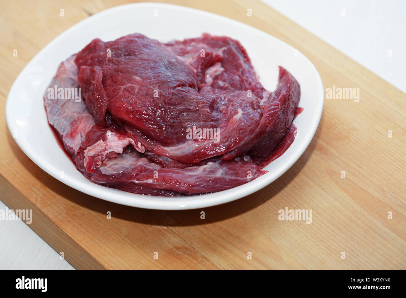 Teil von rohem Rindfleisch für das Kochen auf weiße Platte Stockfoto