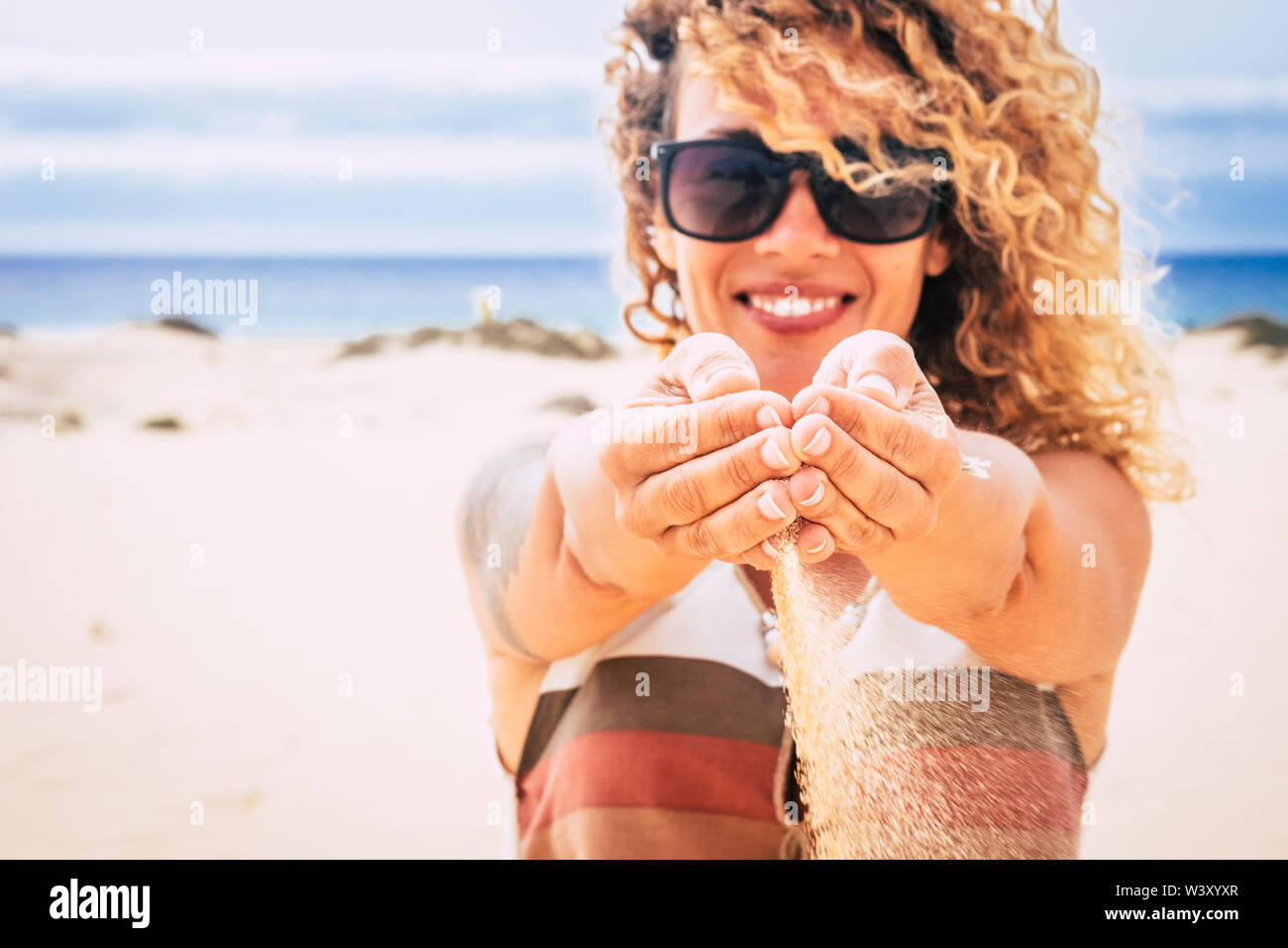 Konzept der Reisen Menschen und Sommerurlaub Urlaub im Resort mit perfekten Strand - fröhlich glücklich schöne Frau Sand hinterlassen Fallen aus ihren Händen Stockfoto Konzept der Reisen Menschen und Sommerurlaub Urlaub im Resort mit perfekten Strand - fröhlich glücklich schöne Frau Sand hinterlassen Fallen aus ihren Händen Stockfoto