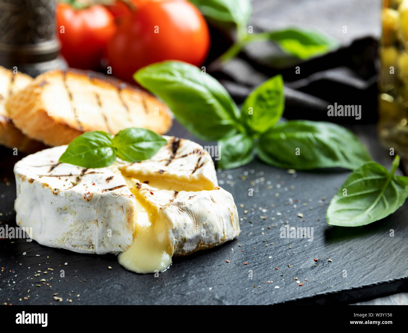 Camembert Grill, auf schwarzen Stein Hintergrund Stockfoto