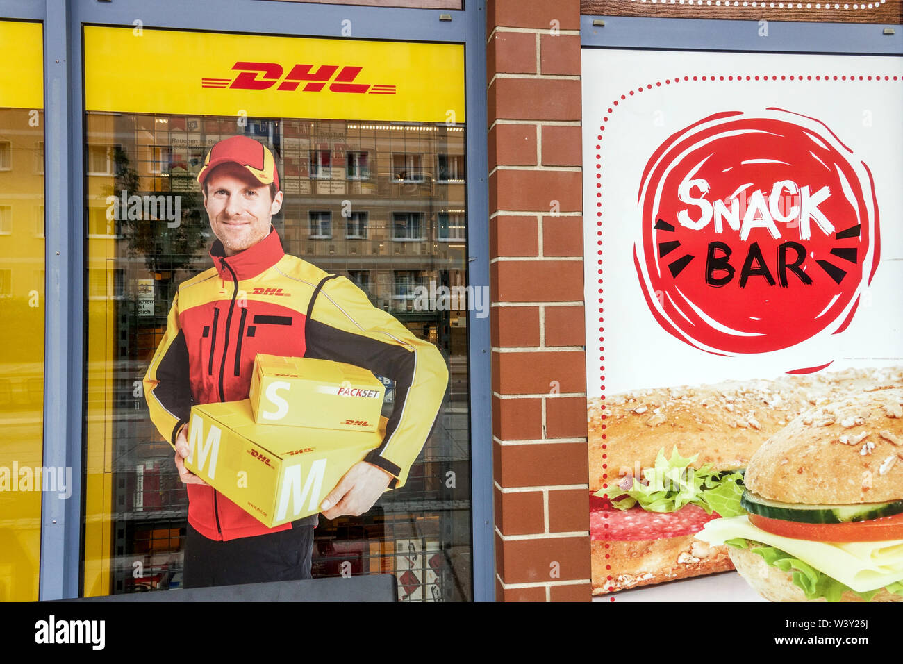 DHL Delivery man, eine Anzeige auf DHL Office Shop, Snack Bar auf der Straße Dresden Deutschland Stockfoto