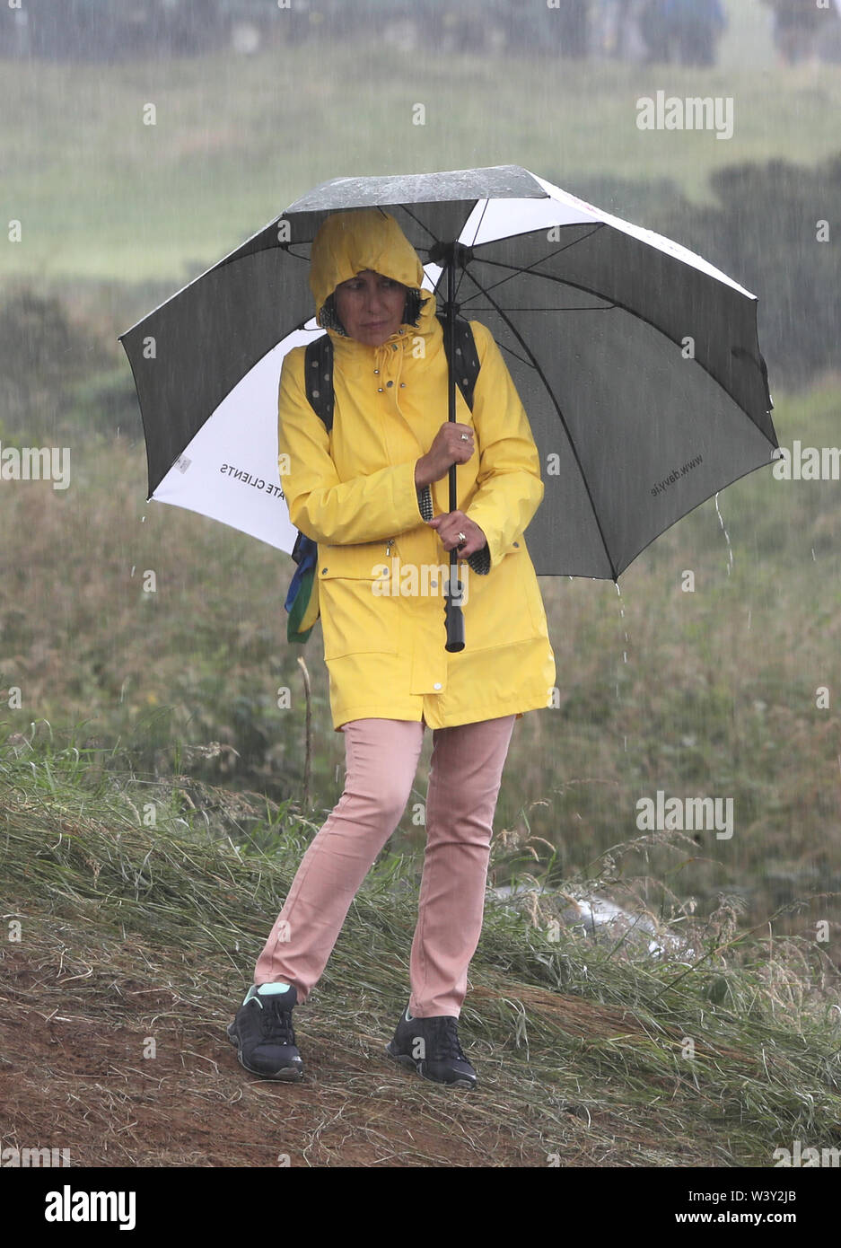 Zuschauer schirmt sich von der Regen während der Open Championship 2019 im Royal Portrush Golf Club. Stockfoto