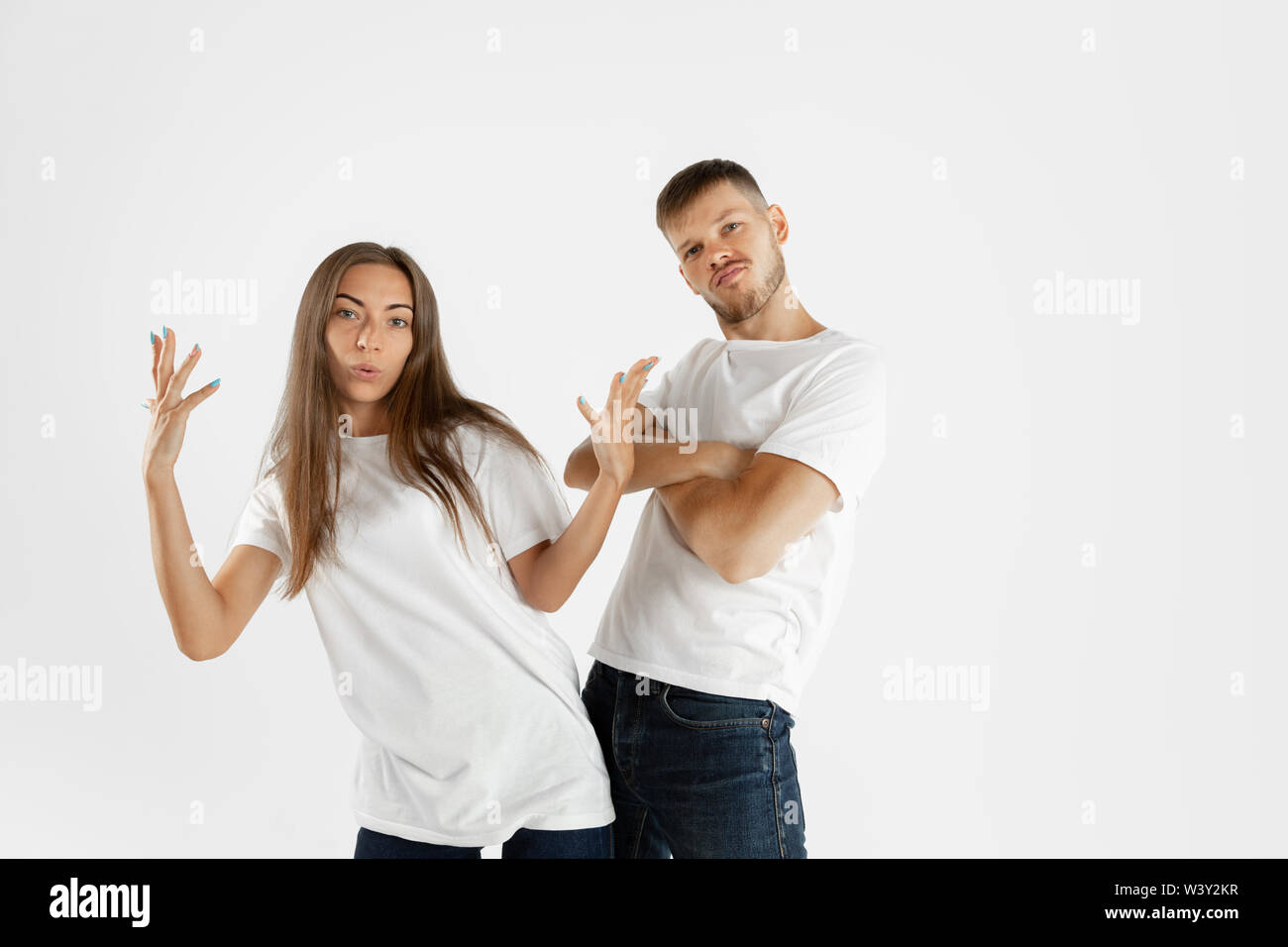 Die schöne junge Paar portrait Studio isoliert auf weißem Hintergrund. Mimik, menschliche Gefühle, Werbung Konzept. Copyspace. Frau und Mann Kreuzung Hände oder Tanzen, cool aussehen. Stockfoto