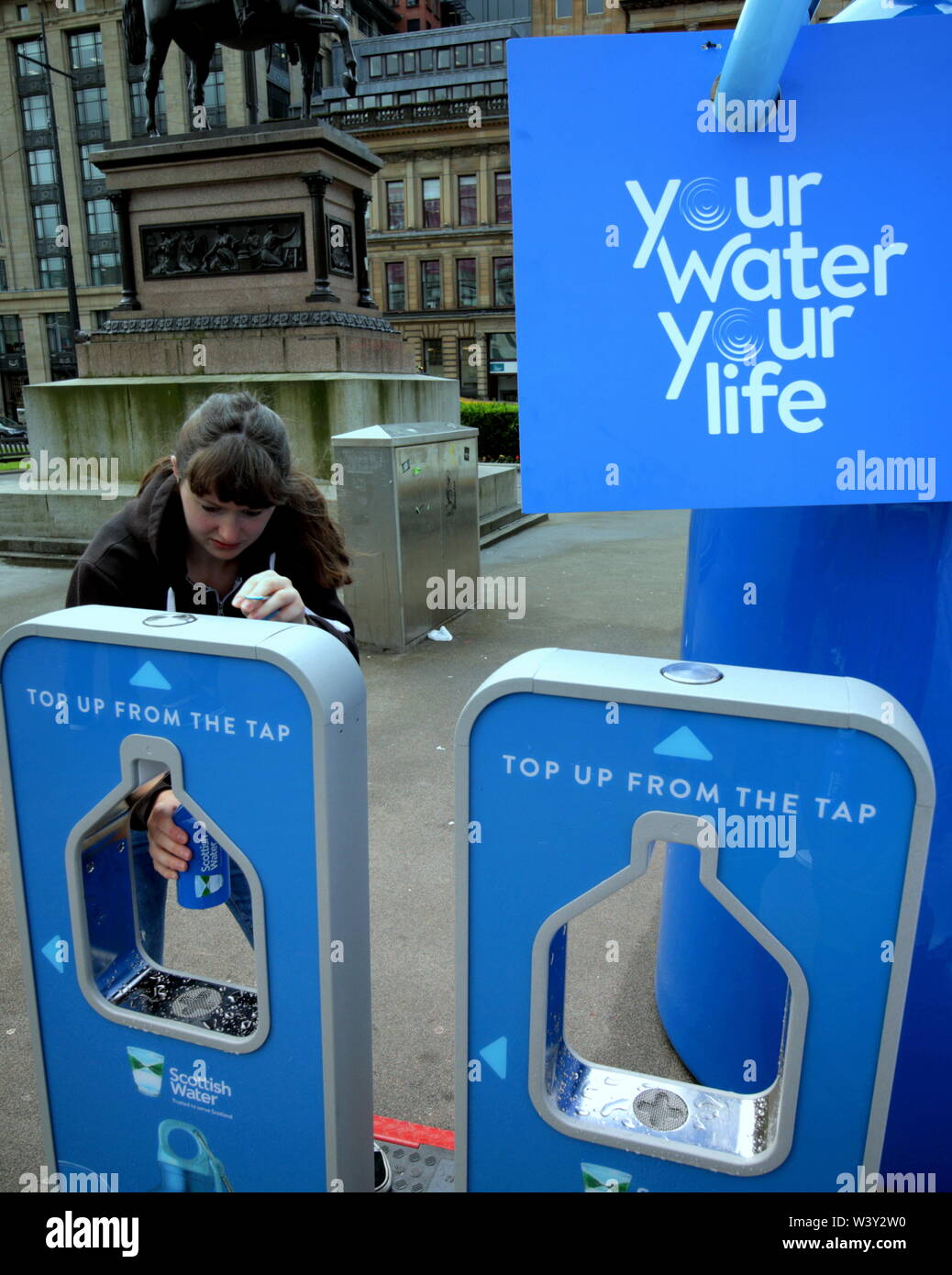 Glasgow, Schottland, Großbritannien, 18. Juli 2019. Schottisches Wasser Ihre gratis Wiederbefüllung Straße Maschinen mit einer entfernt im Stadtzentrum George Square geben, um ihr Engagement für eine grünere Welt mit Menschen ihre Flaschen nachfüllen statt Kauf Kunststoff zu bestätigen gefeiert, Sie haben eine permanente Maschine in der Sty. le Meile der Stadt Buchanan Street Gerard Fähre / alamy Leben Nachrichten Stockfoto