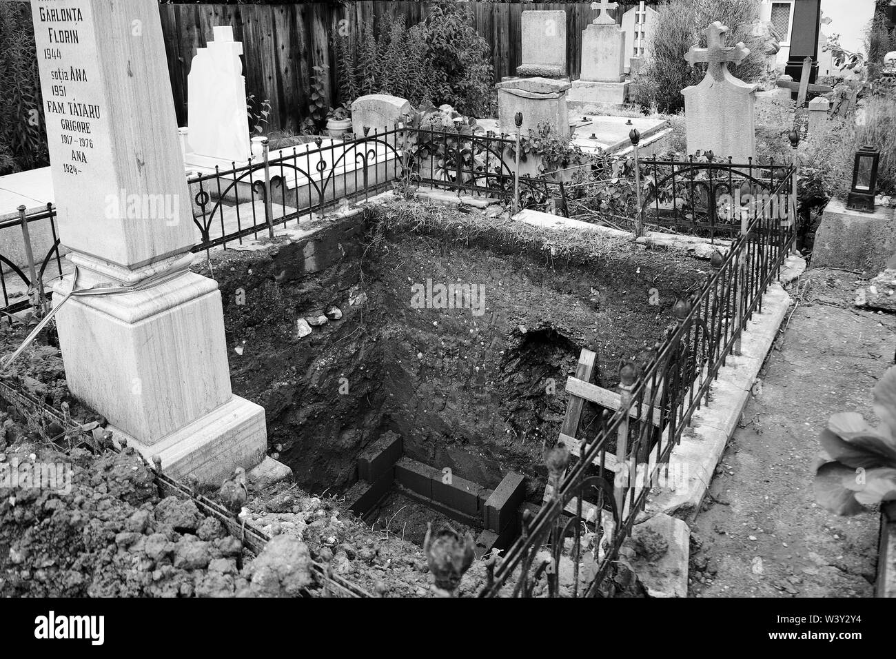 Große grab Grundstück tief gegraben, um eine verstorbene Familienmitglied in einem christlichen Friedhof zu beerdigen. Schwarz und Weiß Stockfoto