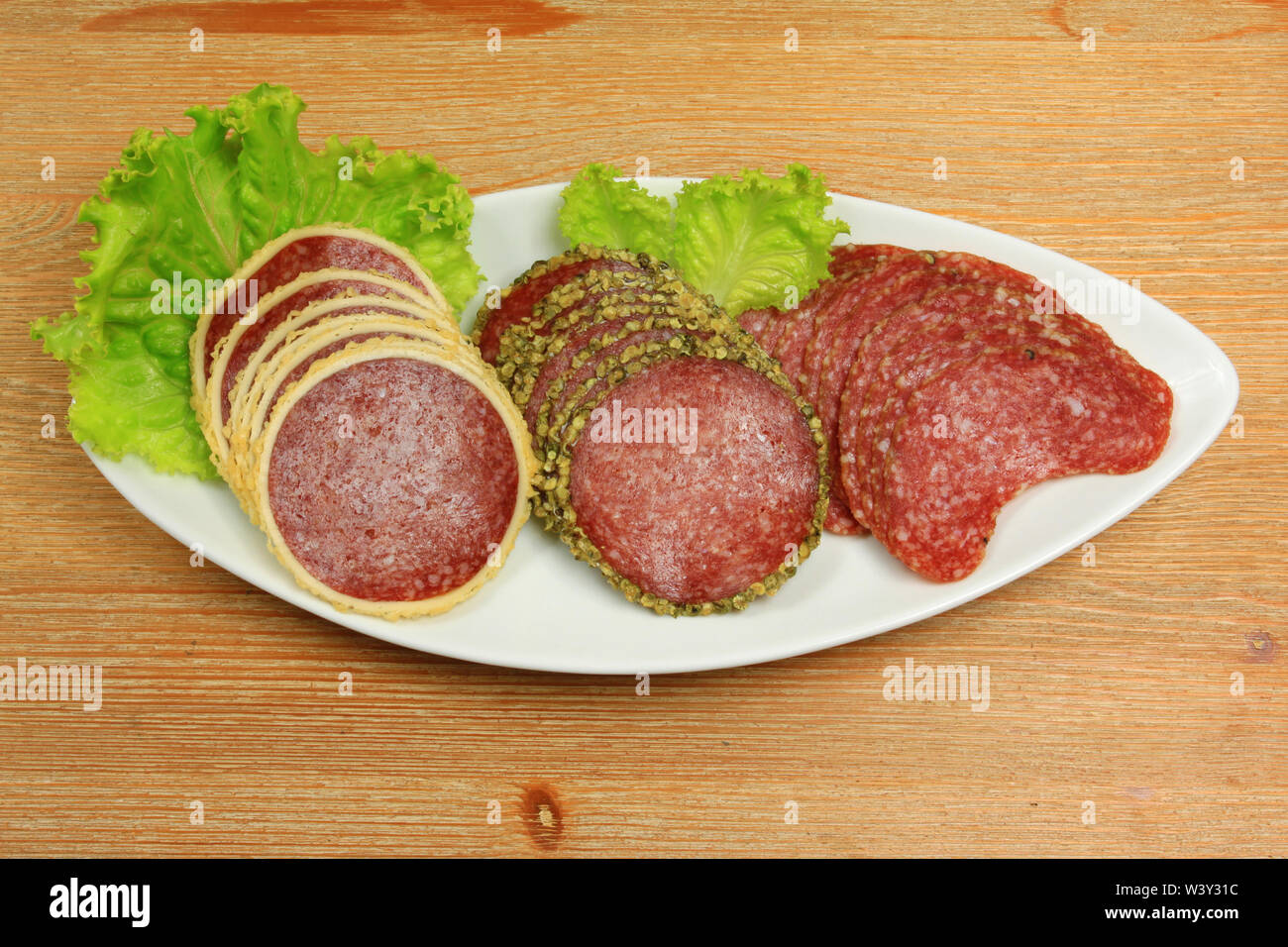 Drei verschiedene Arten von Salami Fleisch auf und Veranstaltungsräume Platte mit Salat Stockfoto