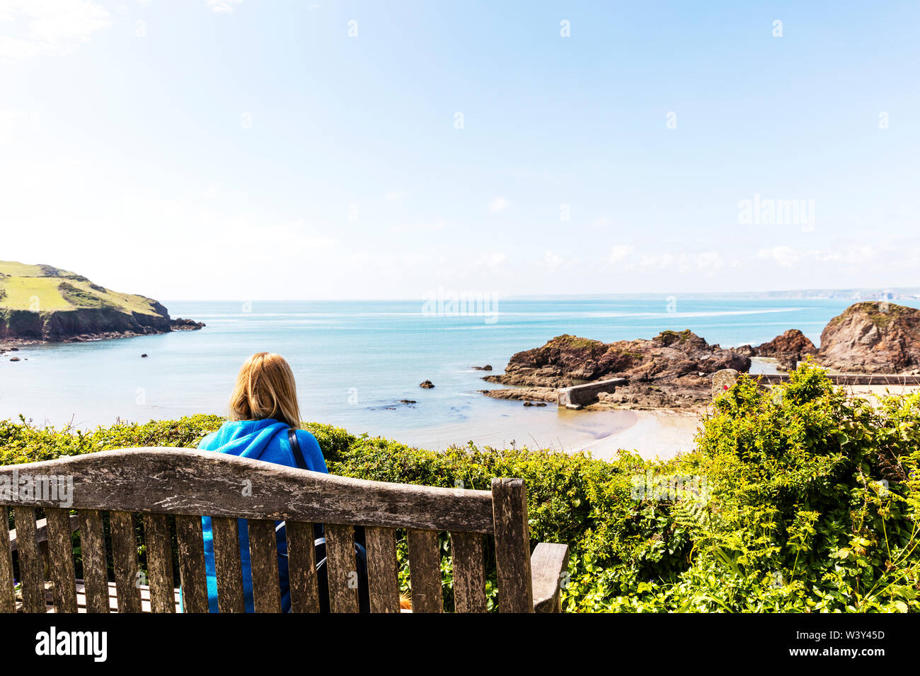 Mit Blick auf das Meer, Träumen, Fernweh, Tag träumen, nachdenken, Verzweiflung, Hoffnung, nachdenklich, allein mit dem Gedanken, allein, saß auf der Bank, Frau Stockfoto