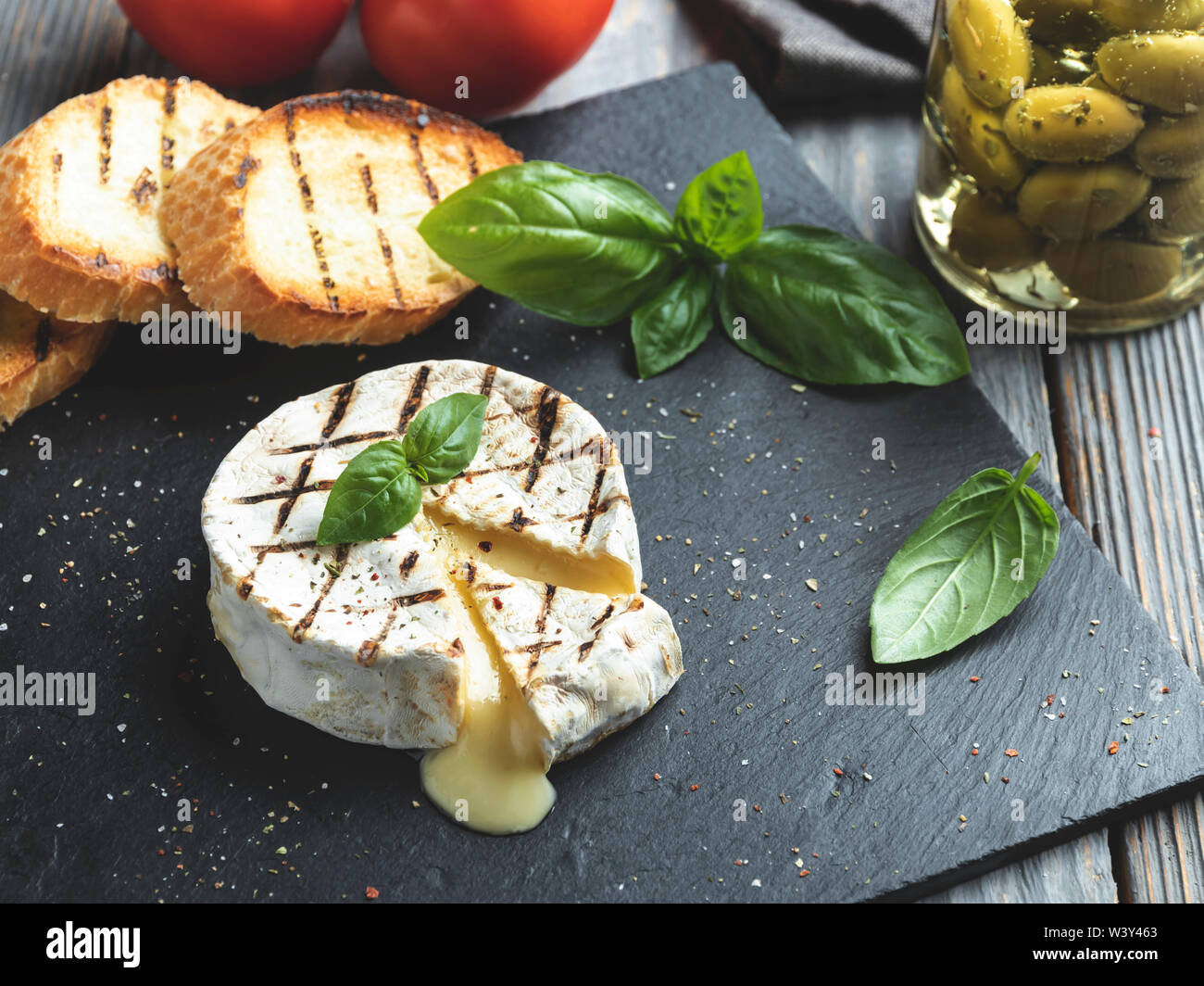 Camembert Grill, auf schwarzen Stein Hintergrund Stockfotografie - Alamy
