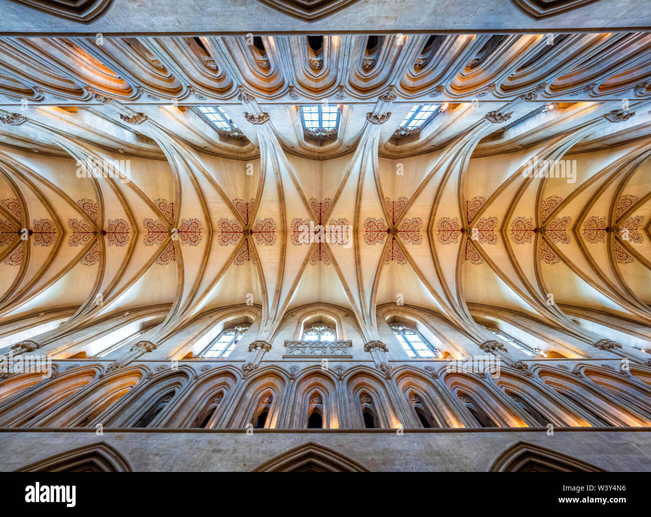 Hohe gewölbte Decke des Kirchenschiffes von Wells Cathedral in Somerset UK mit architektonischen Details aus lackiertem florale Muster in rot und blau markiert Stockfoto