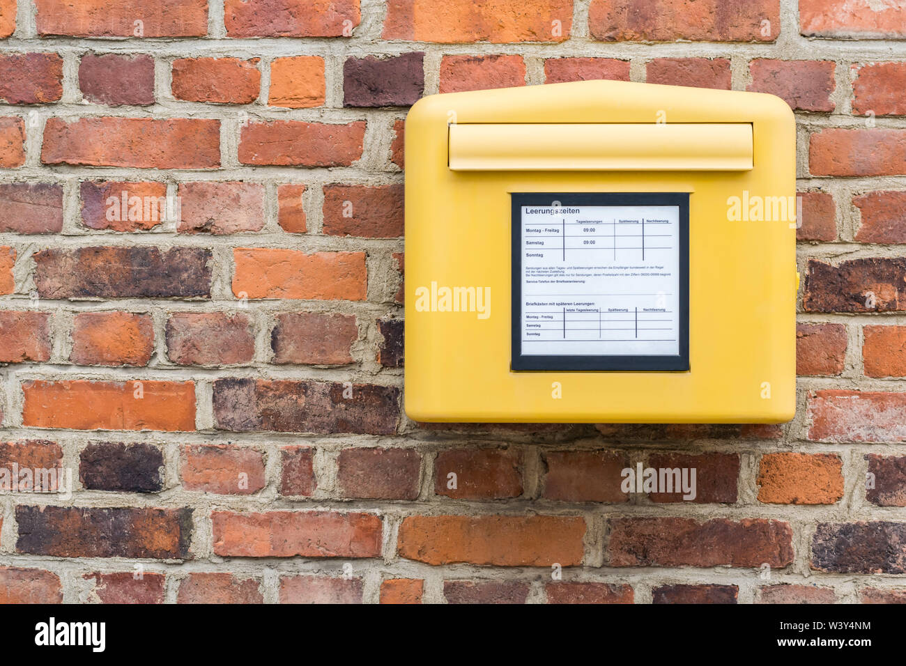 Deutsche gelbe Briefkasten auf Wand Stockfoto