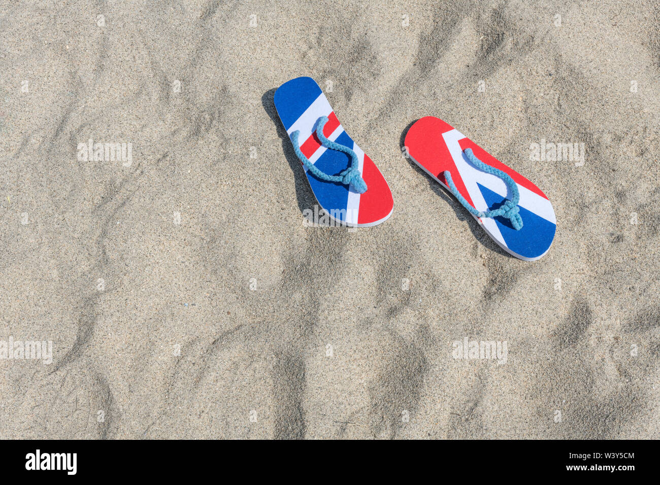 GB-Flagge / Union Jack Flip-Flops am Sandstrand - frr 2021 UK Aufenthalt, Urlaub zu Hause, Aufenthalt Cornwall, Badeurlaub, Flip-Flop-Schuhe. Stockfoto