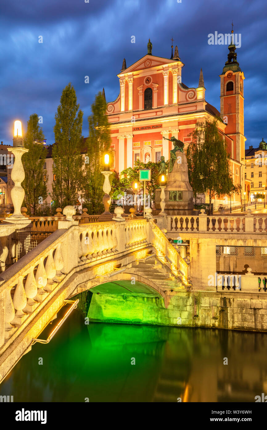 Die Rosa Franziskanerkirche und die drei Brücken über den Fluss Ljubljanica nachts Ljubljana Slowenien EU-Europ Stockfoto