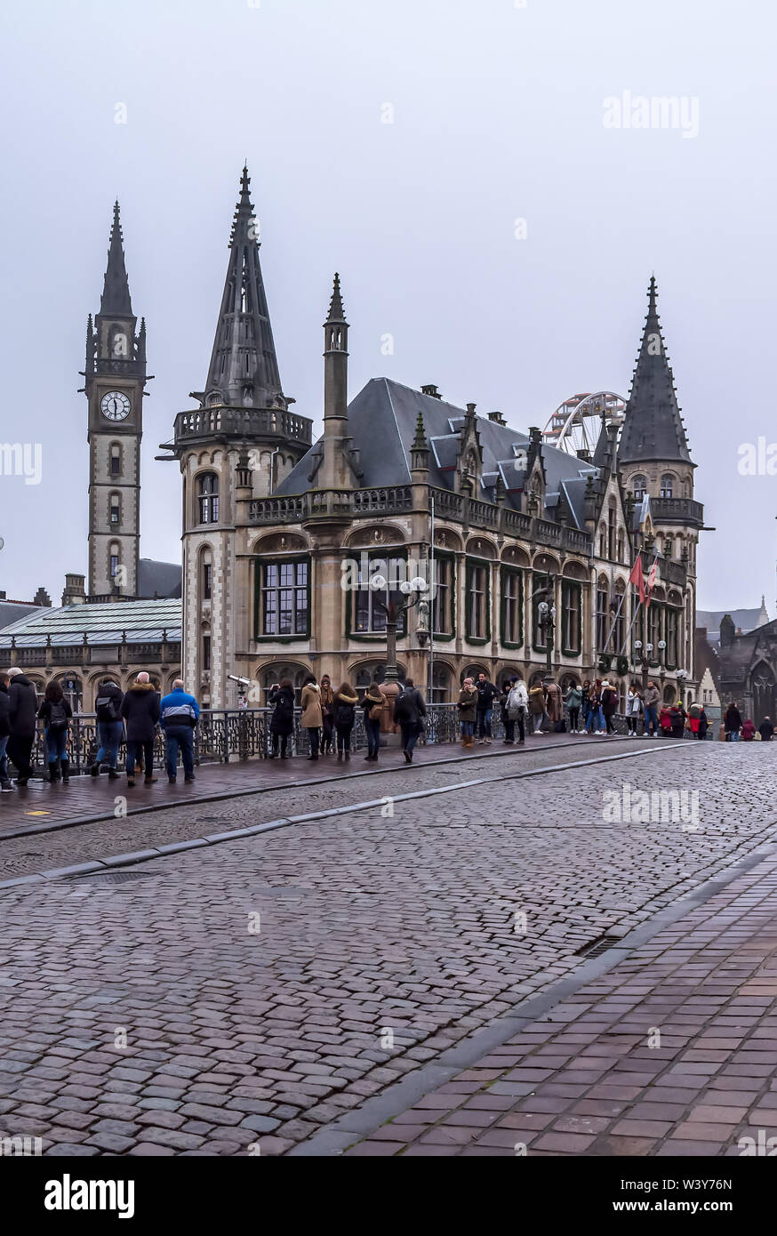 Touristen machen Fotos stehen auf Sint-Michielsbrug oder St Michael's Bridge in der Nähe von alten Postgebäude in nebligen Winter morgen. Stockfoto