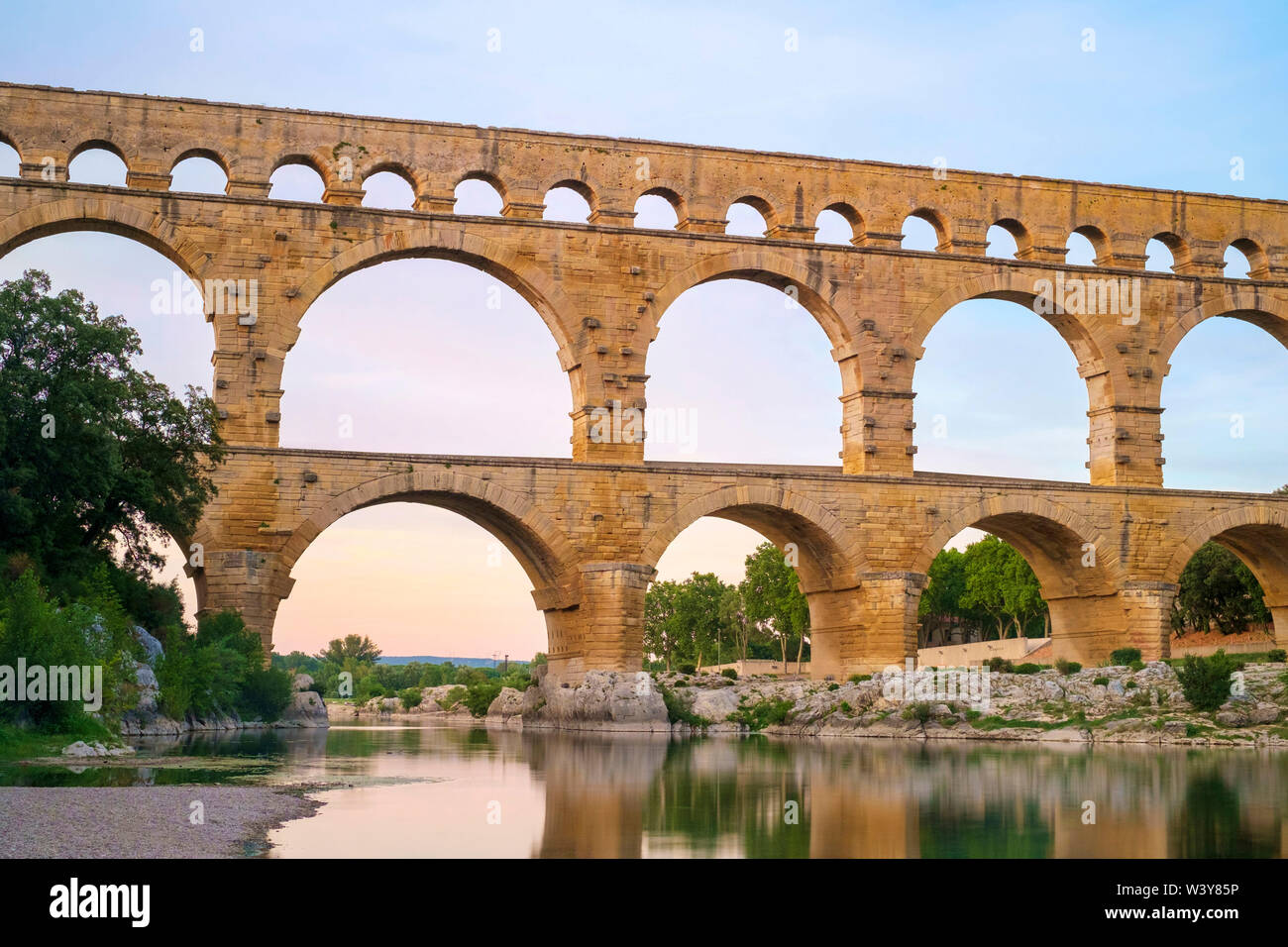 Römische Aquädukt Pont du Gard über Gard Fluss bei Sonnenuntergang, Departement Gard, Languedoc-Roussillon, Frankreich Stockfoto