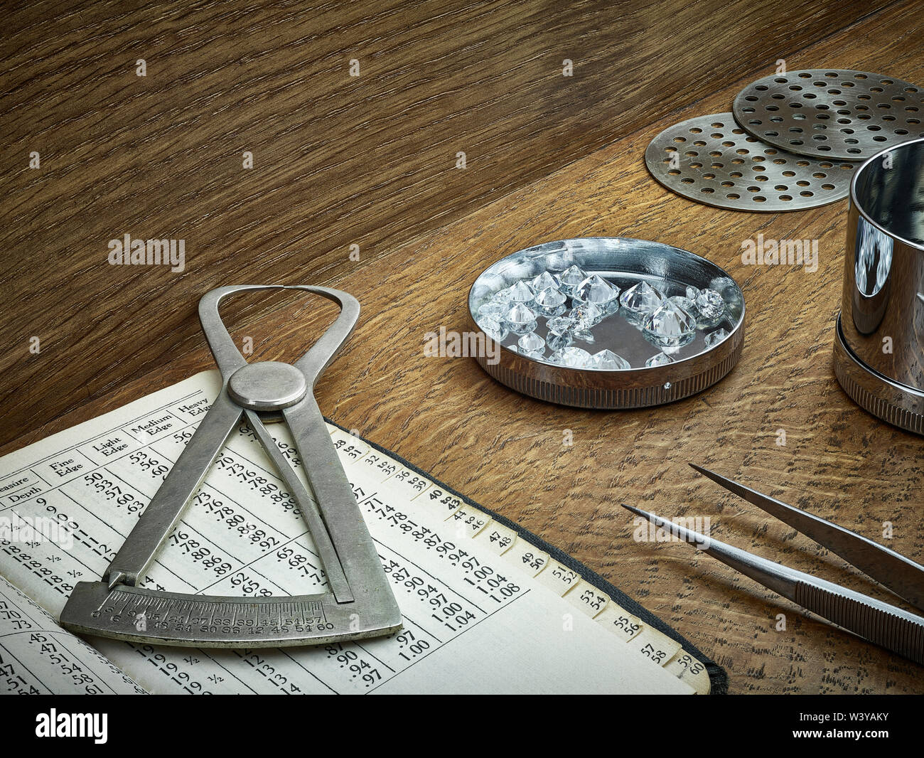 Diamond Grading Werkzeuge und Instrumente mit lose Diamanten auf Holz Hintergrund. Sieb, Pinzette und Diamond Manometer mit Diamond Messung Buch. Stockfoto