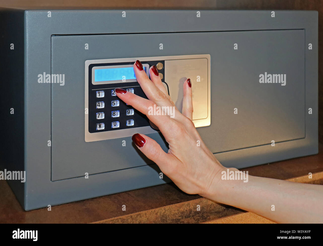 Weibliche Hand einen Code zur Verriegelung auf einem Hotelsafe Stockfoto