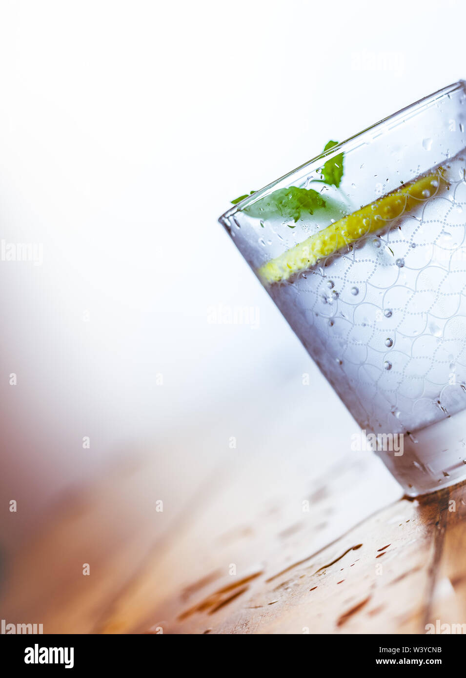 Ein Becherglas und einen Krug kalten Limonade auf einem weißen Hintergrund Holz umgeben von Zitronen Stockfoto
