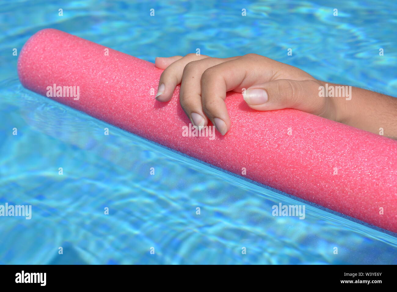 Die junge Frau Hand ruht auf einem Pool Nudel in einem Schwimmbad. Sommer vibes, cool bleiben Stockfoto