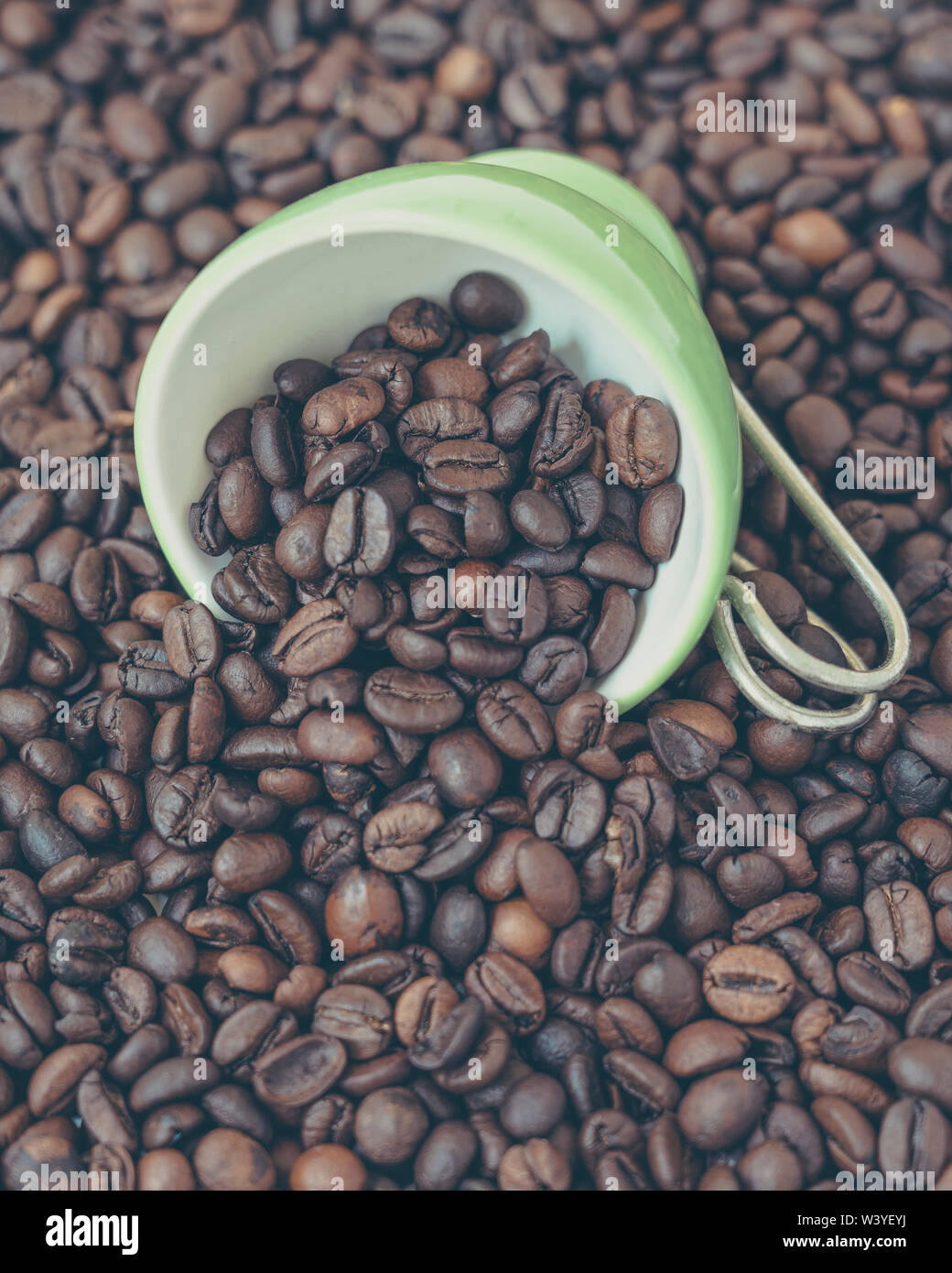 Grüne Schale unter eine Menge Kaffee Bohnen. Stockfoto