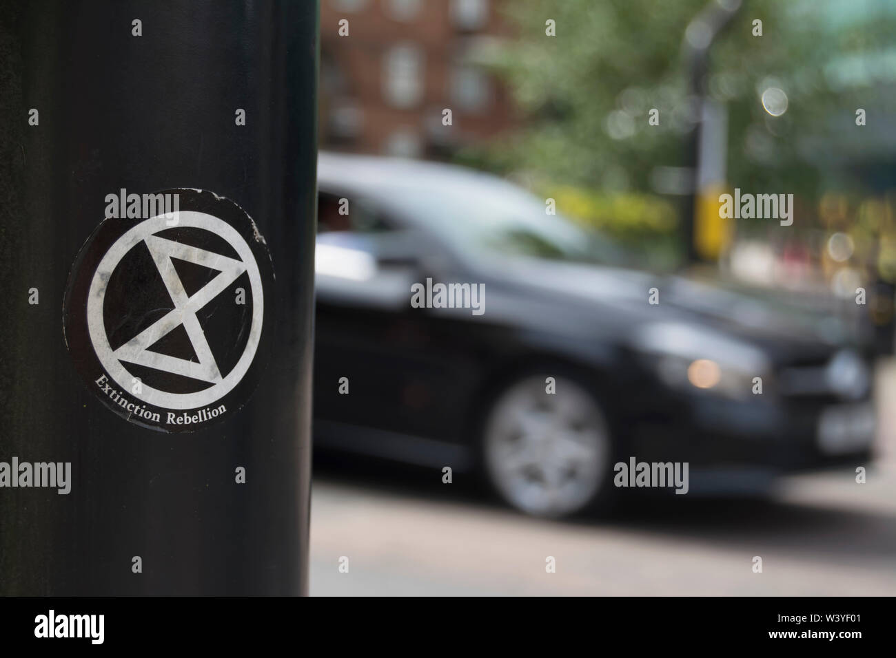 Aussterben rebellion Aufkleber mit Logo mit vorbeifahrenden Auto in blured Bewegung gesehen, in Putney, London, England Stockfoto