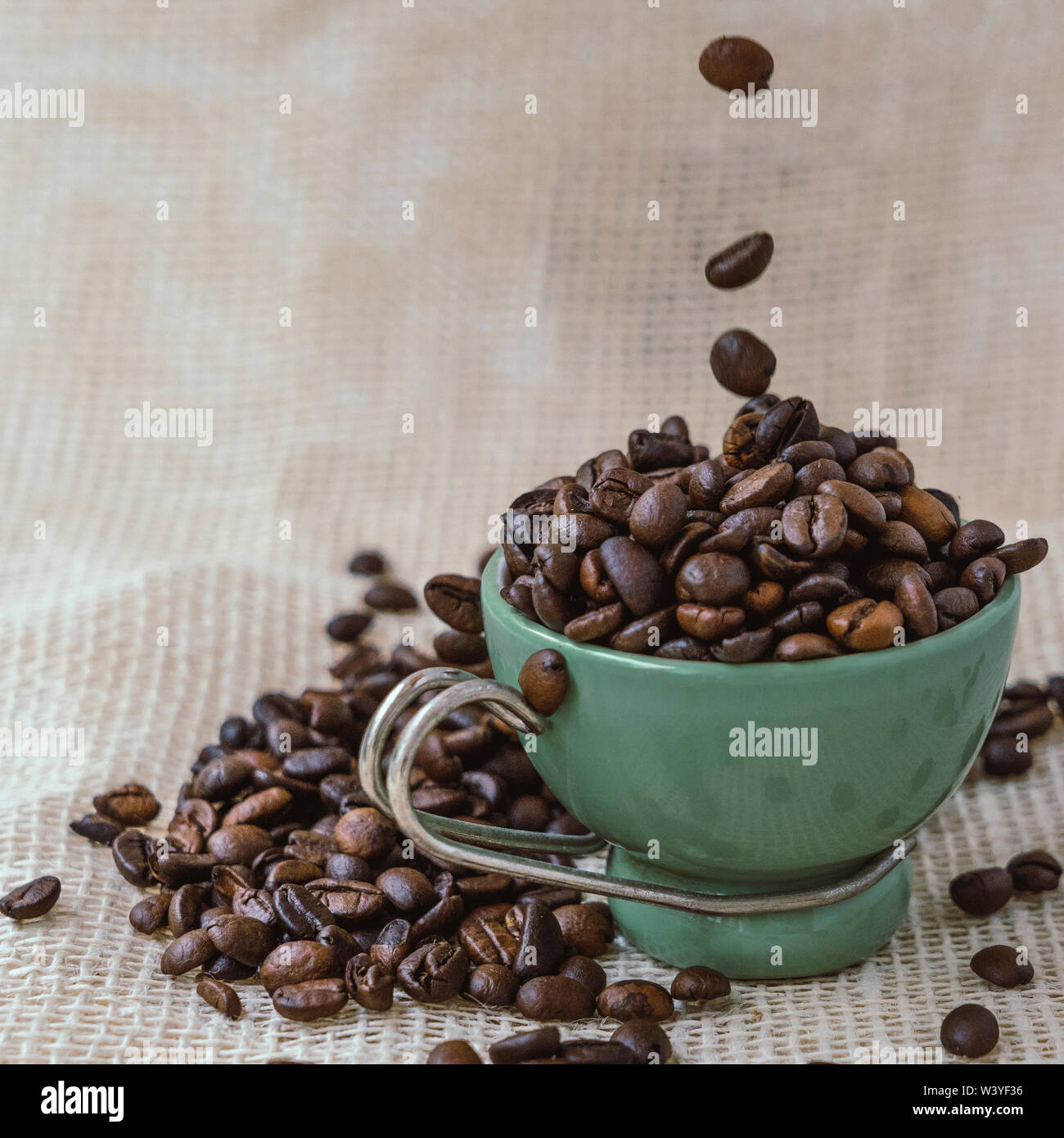 Grüne Schale unter eine Menge Kaffee Bohnen auf Jute Tasche. Stockfoto