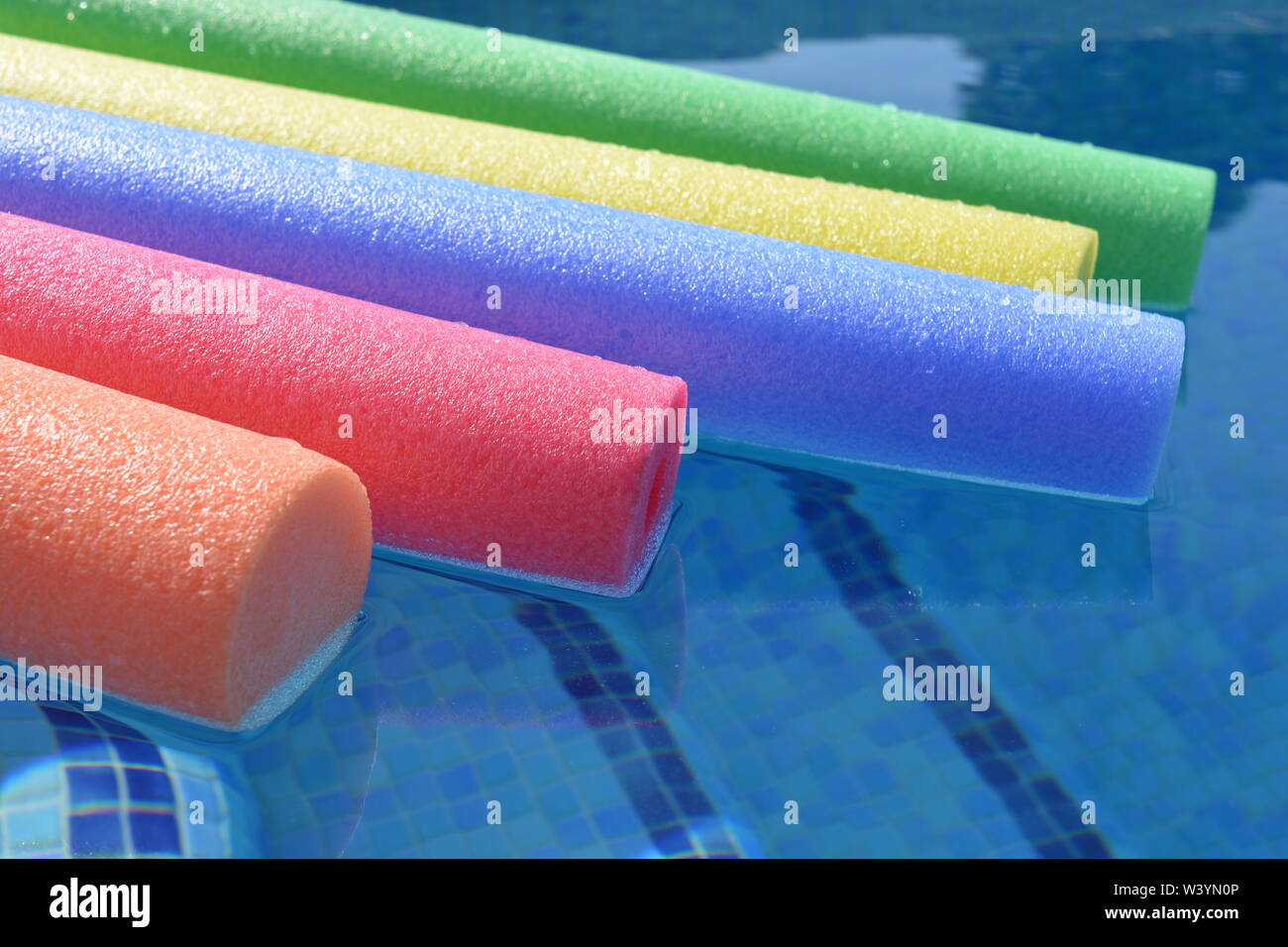 Bunte pool Nudeln schwimmen Im Schwimmbad, in der Nähe. Kreatives Konzept, Sommer vibes, Freizeit und Erholung. Stockfoto