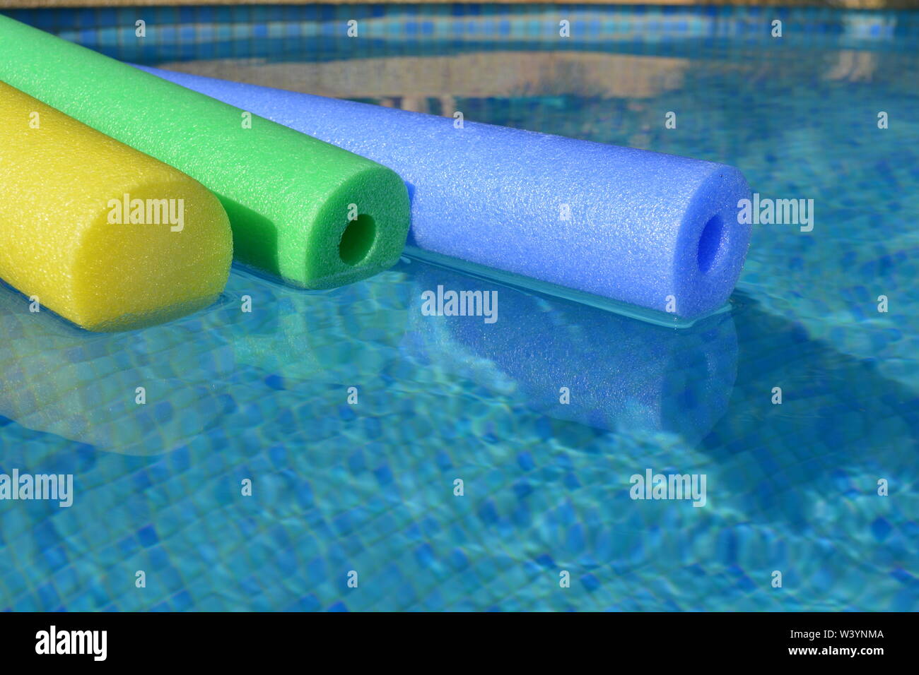 Bunte pool Nudeln schwimmen Im Schwimmbad, in der Nähe. Kreatives Konzept, Sommer vibes, Freizeit und Erholung. Stockfoto