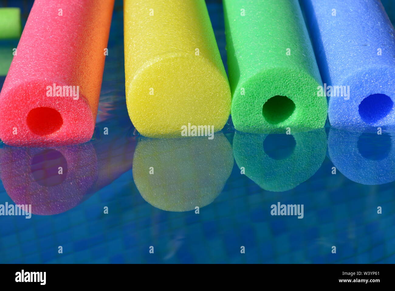 Bunte pool Nudeln schwimmen Im Schwimmbad, in der Nähe. Kreatives Konzept, Sommer vibes, Freizeit und Erholung. Stockfoto