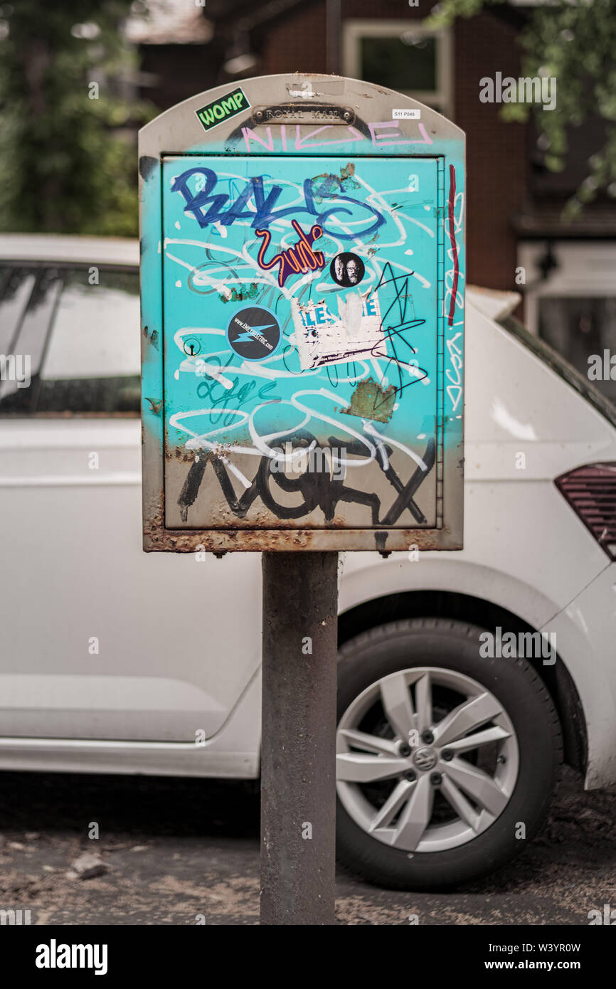 SHEFFIELD, UK - 13. JULI 2019: Teenager verwüstet haben ein Royal Mail Post Box mit Graffiti auf einer Straße in Sheffield Stockfoto