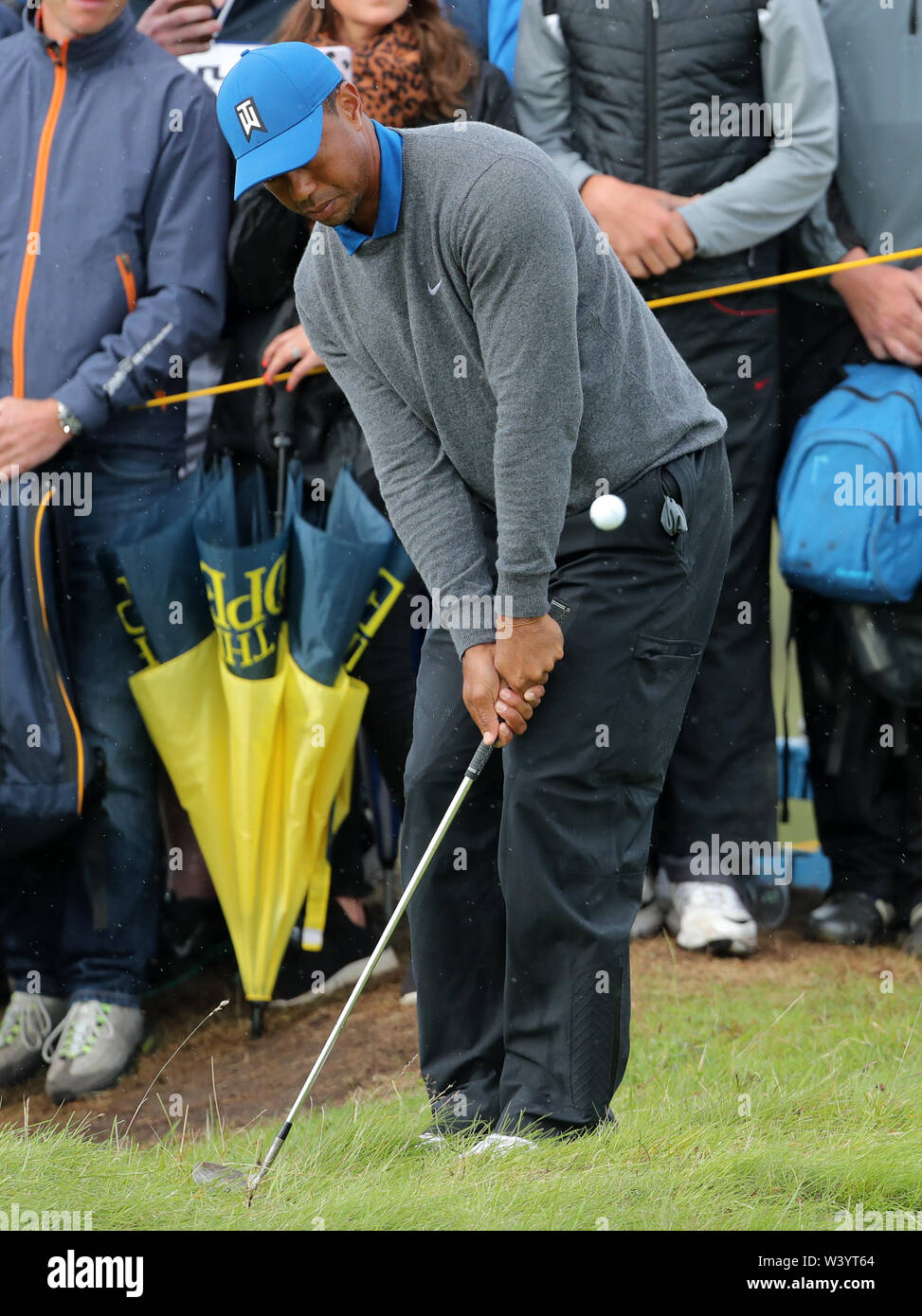 Die USA Tiger Woods Chips vom rauhen während des Tages eine der Open Championship 2019 im Royal Portrush Golf Club. Stockfoto