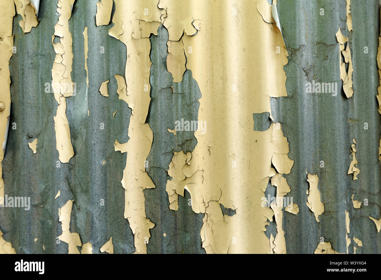 Nahaufnahme des gelben Lack Peeling aus Wellpappe tin Wand Hintergrund Stockfoto