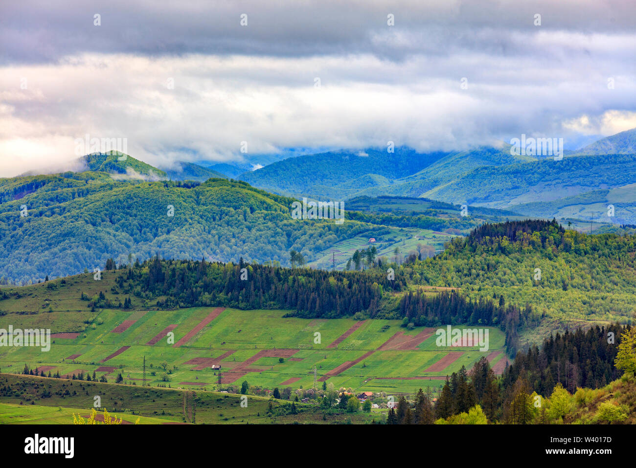 Rechteckige Flächen landwirtschaftliche Flächen der Anwohner werden in einem Tal auf einem Hügel vor dem Hintergrund der malerischen Landschaft der entfernt Stockfoto