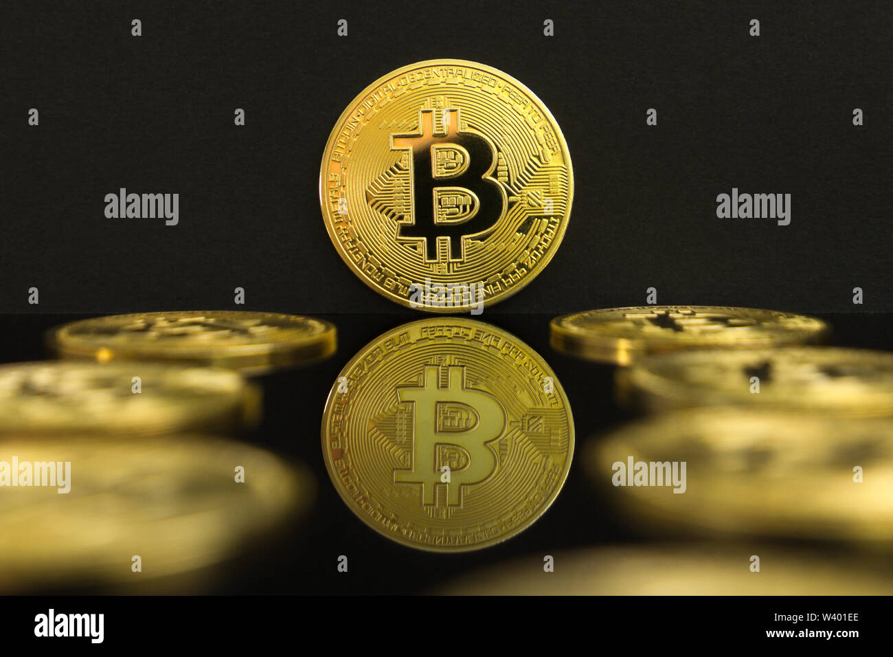 Ein Spiegelbild eines großen goldenen BTC Münzen. Die Münze von bitcoin ist auf einem schwarzen Tisch und schwarzen Hintergrund. Stockfoto