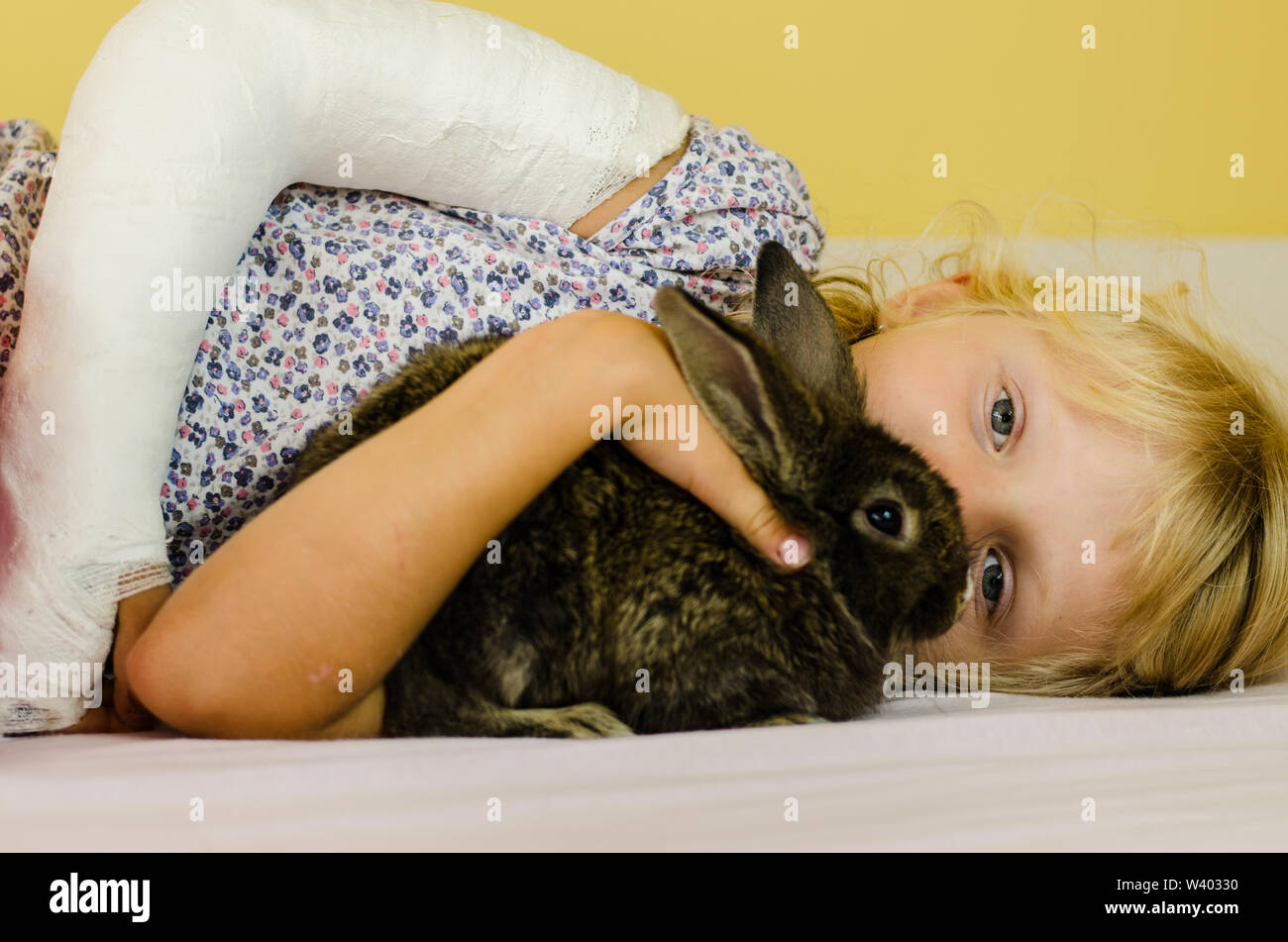 Kaukasische Mädchen mit gebrochenen Schulter und Kaninchen Tier Stockfoto