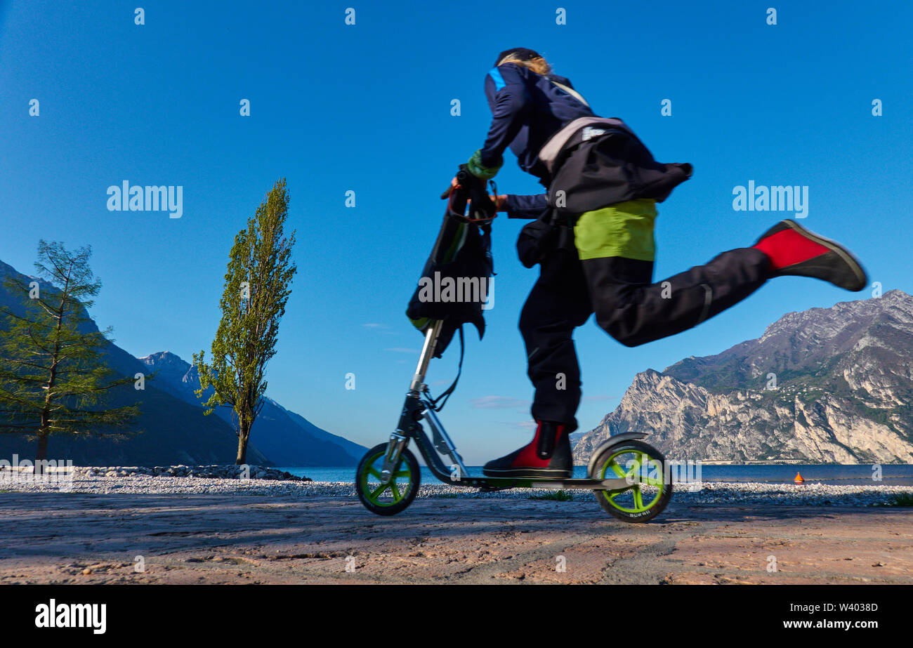 Roller geht am nördlichen Strand bei Sonnenaufgang am kleinen Hafen Porticcioloat Lago di Garda, Gardasee, Torbole - Nago, Riva, Trentino, Italien im April Stockfoto