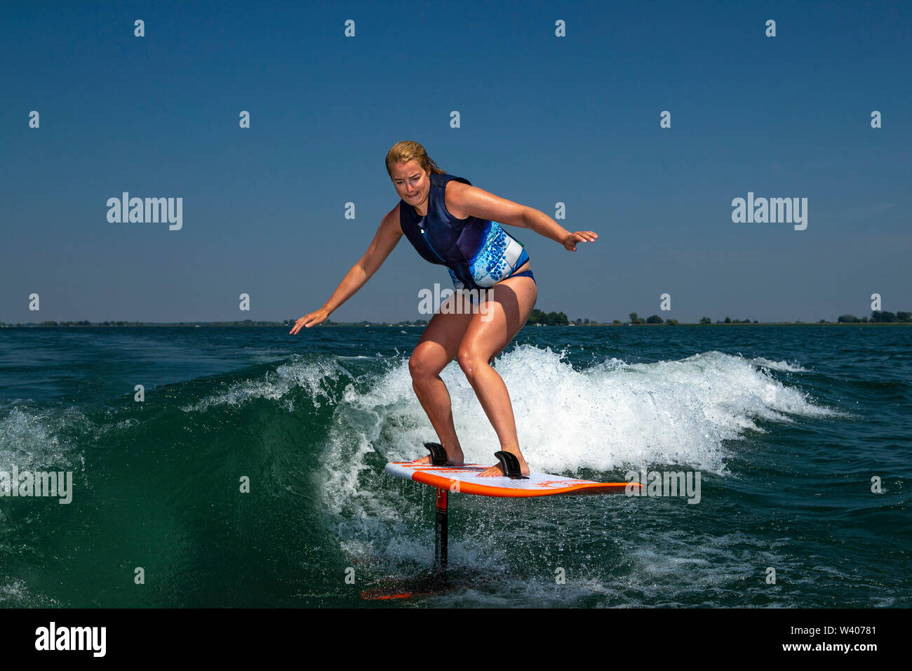 Eine Frau, eine Folie während Wake surfen. Stockfoto