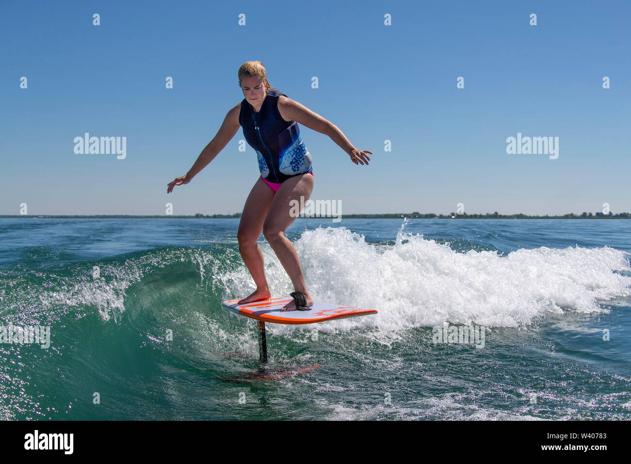 Eine Frau wakesurfing beim Reiten ein Hydrofoil board Stockfotografie