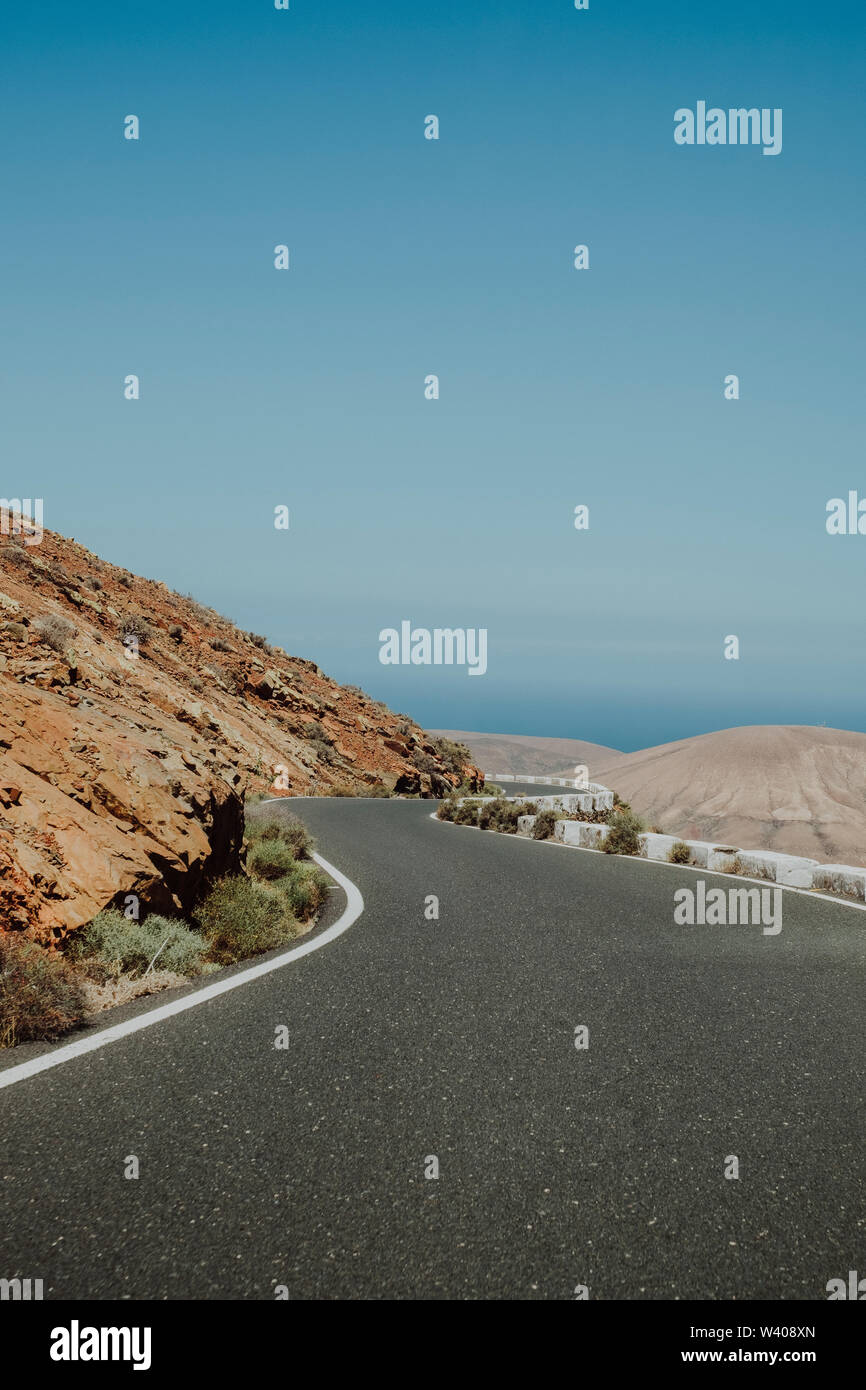 Straße durch die Berge in einer Wüstenlandschaft Stockfoto