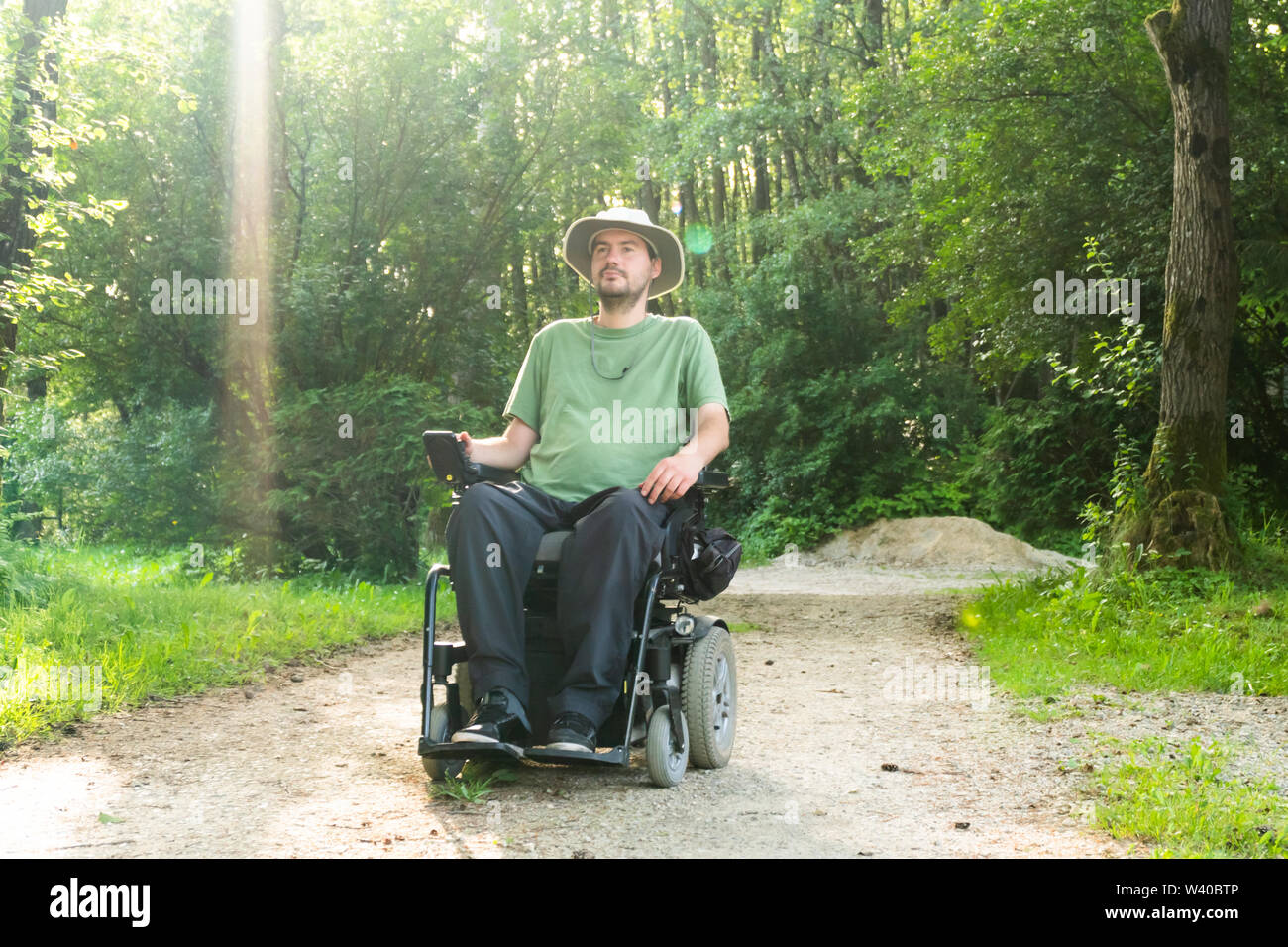 Portrait Foto eines behinderten Menschen in einem elektrischen Rollstuhl in der Natur Stockfoto