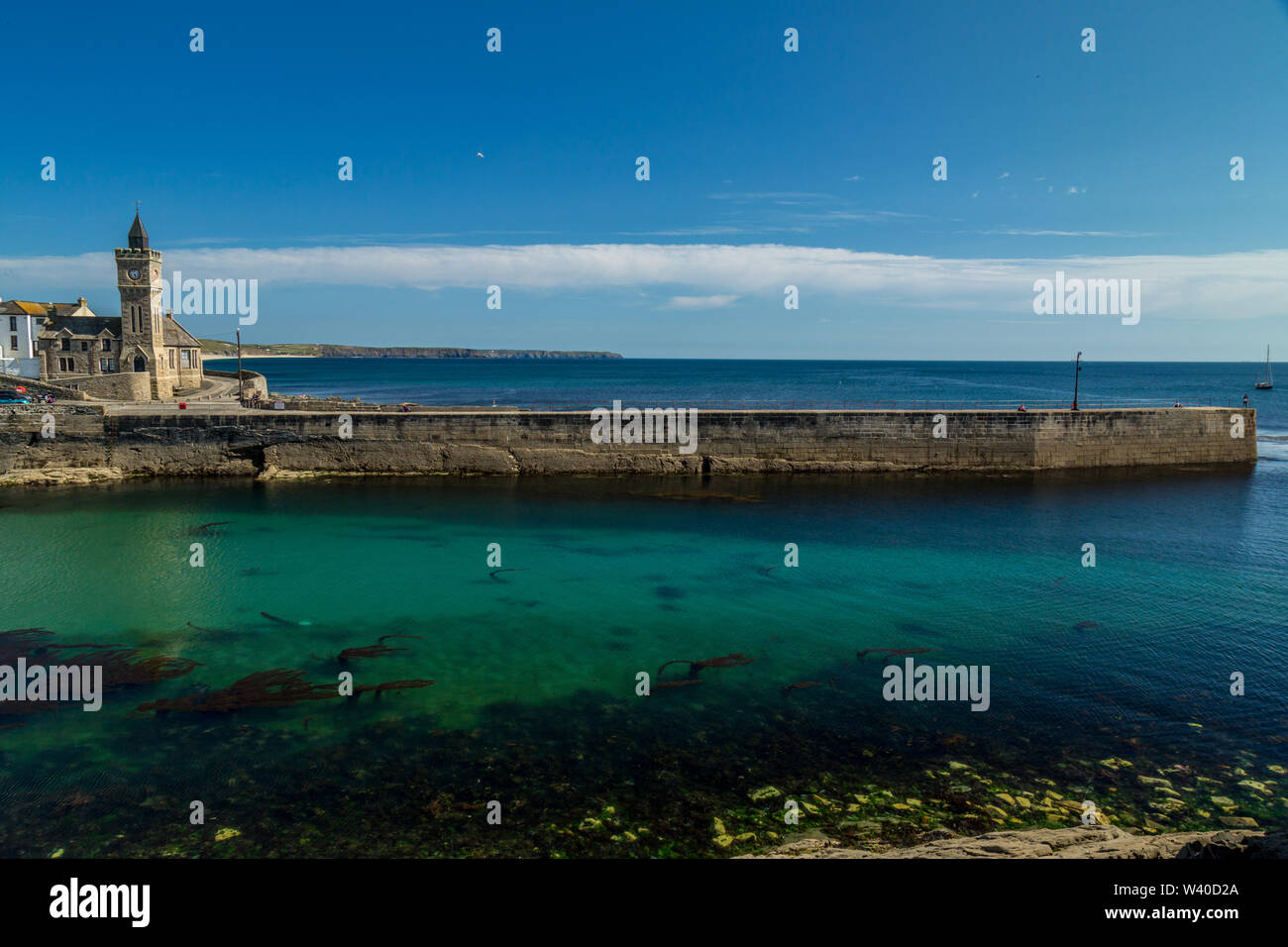 Das seaside Harbour Village von Camborne, Cornwall, England, zeigt die Hafenmauer und Kirche. Stockfoto
